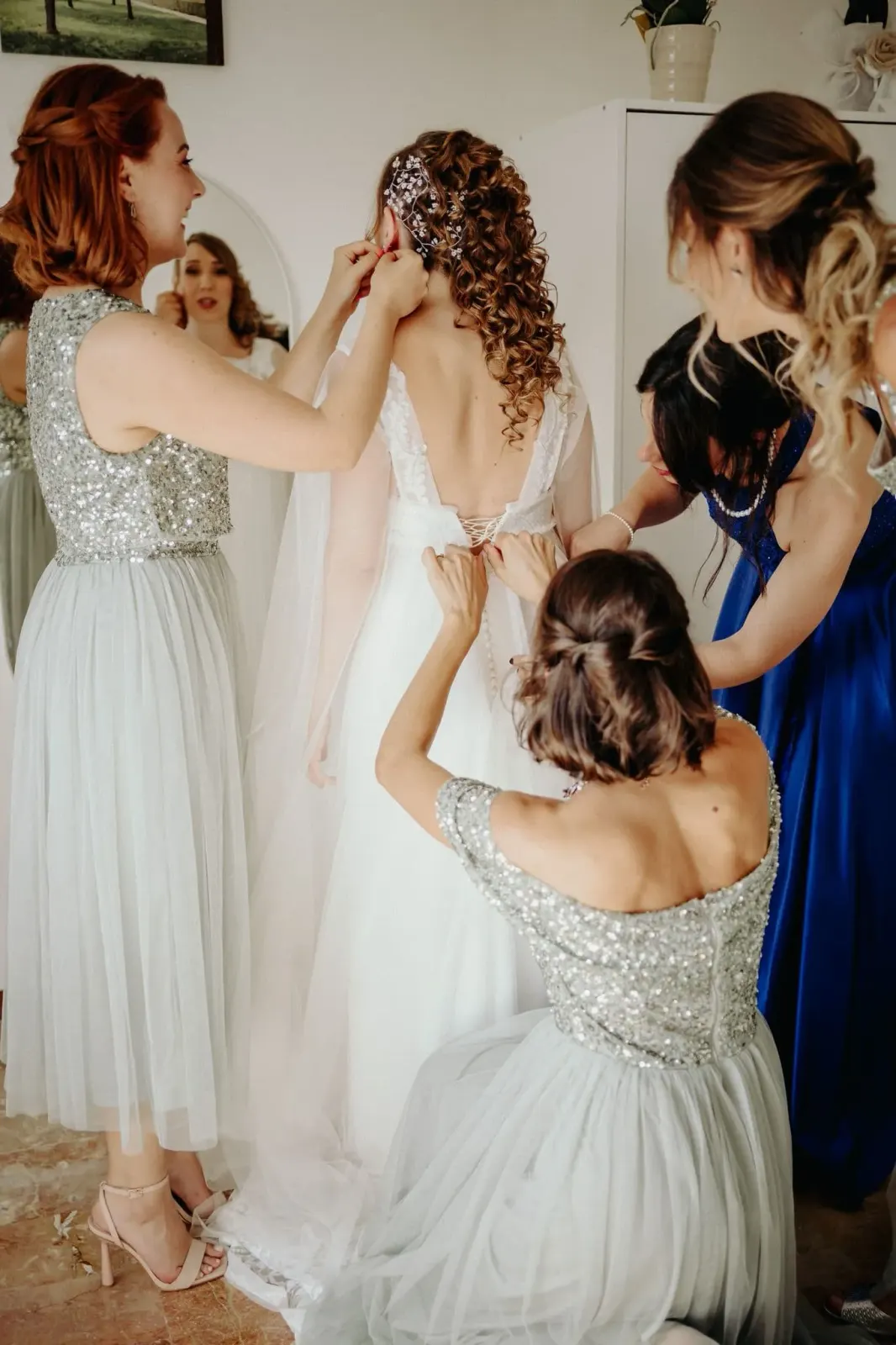 Le damigelle chiudono l'abito della sposa