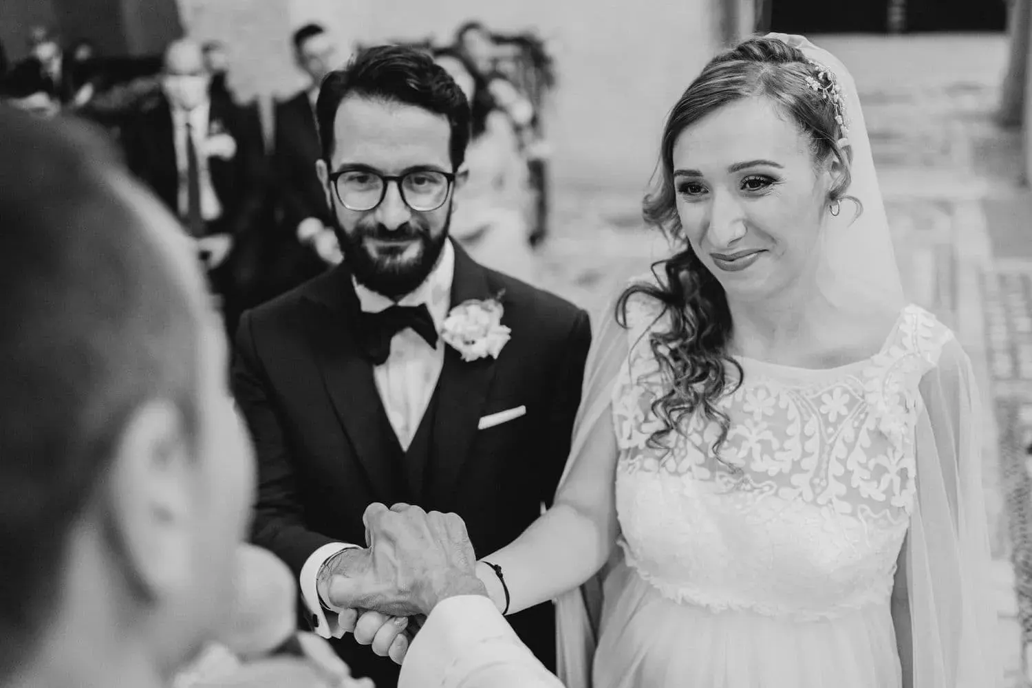 Gli sposi sorridono durante la cerimonia, in bianco e nero