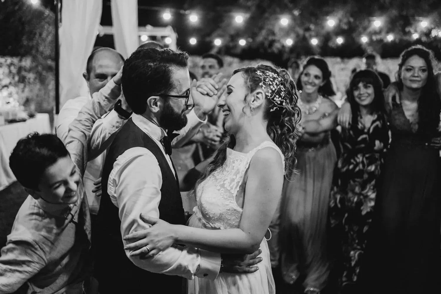 Gli sposi ballano circondati dagli invitati, in bianco e nero