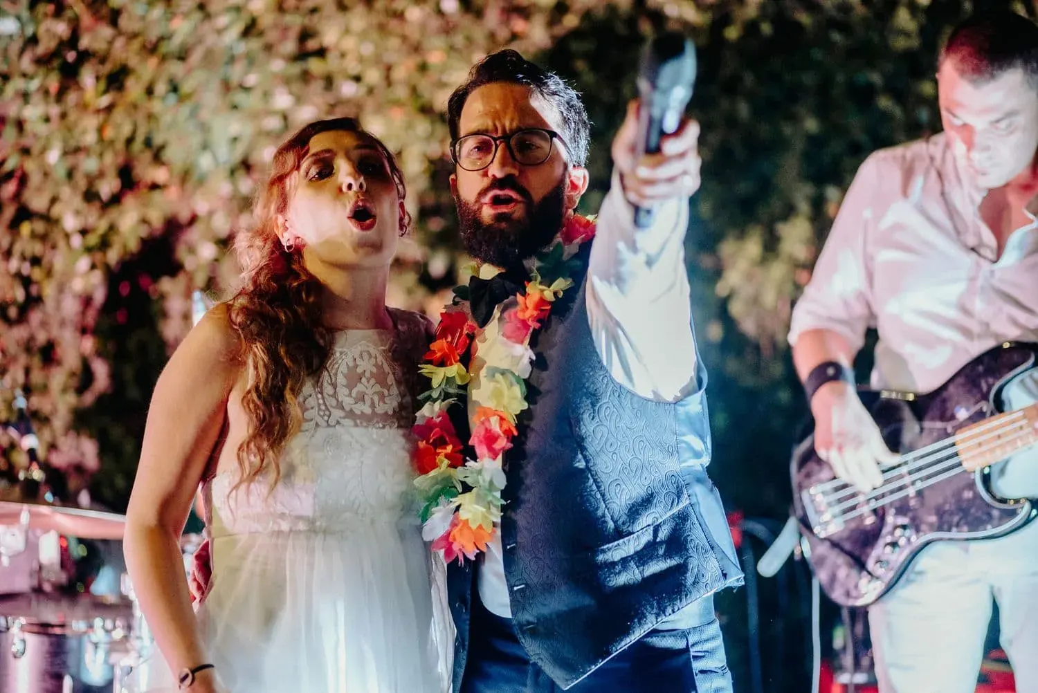 Lo sposo canta con la band con una ghirlanda di fiori al collo