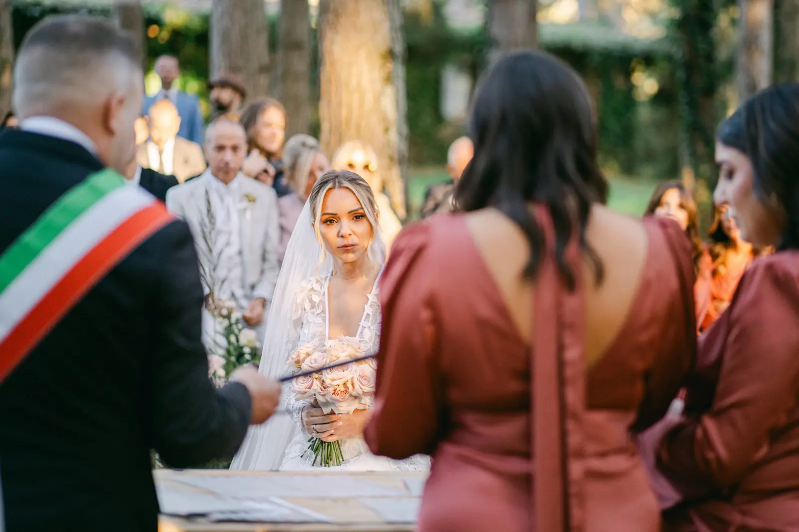 The bride arriving at the ceremony, the officiant with the tricolour sash behind