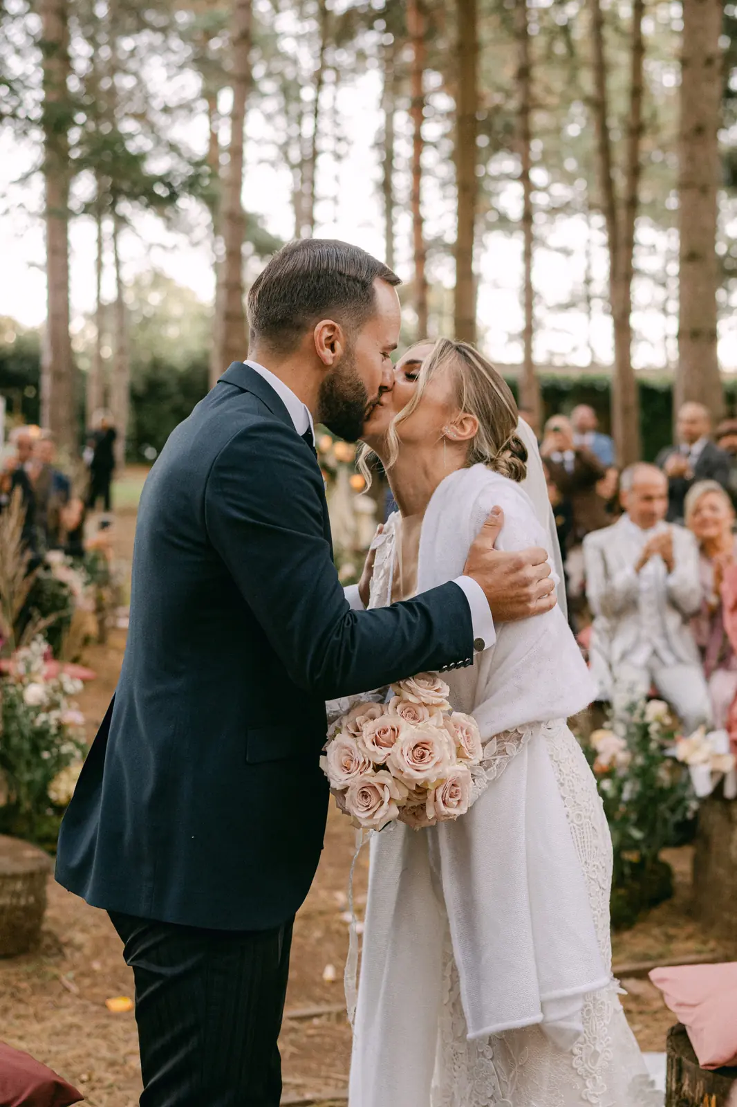 The couple embracing during the ceremony in the woods