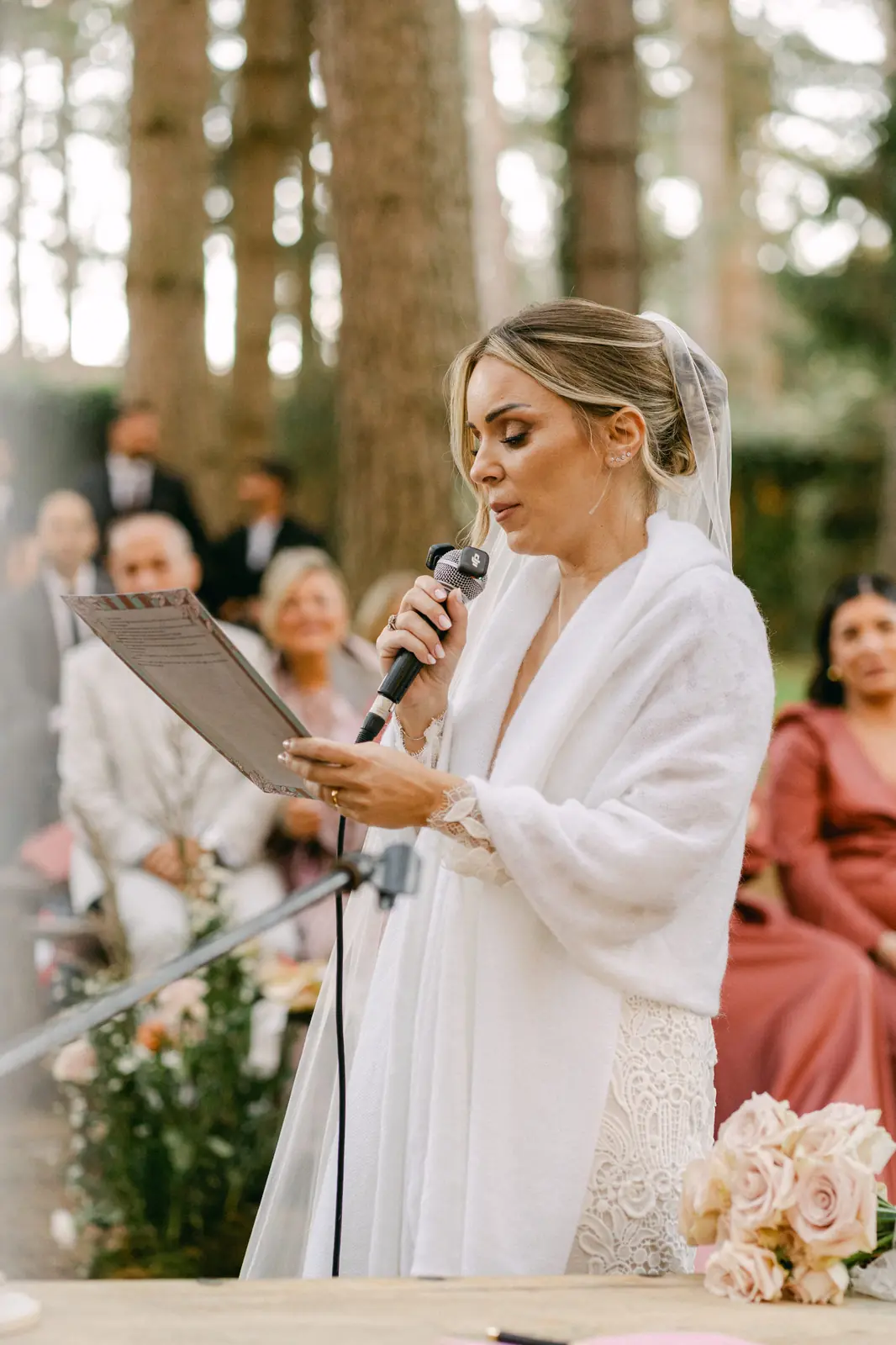 The bride reading her vows into the microphone during the ceremony