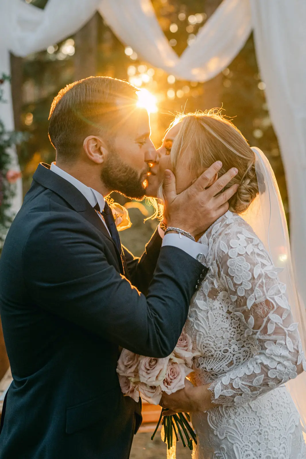 The couple’s first kiss backlit at sunset