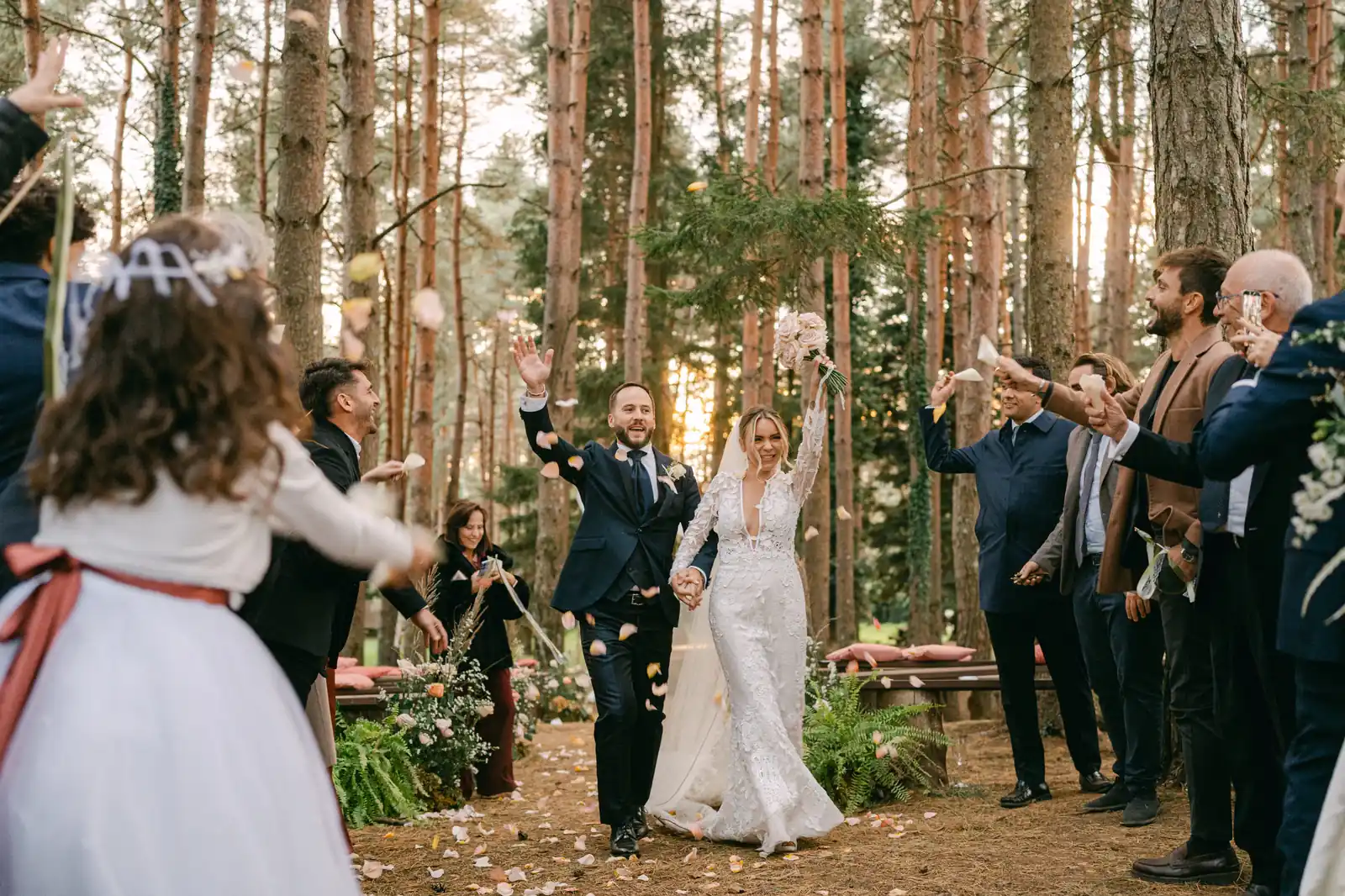 The couple’s exit through a shower of confetti in the pine woods of Parco dei Cimini