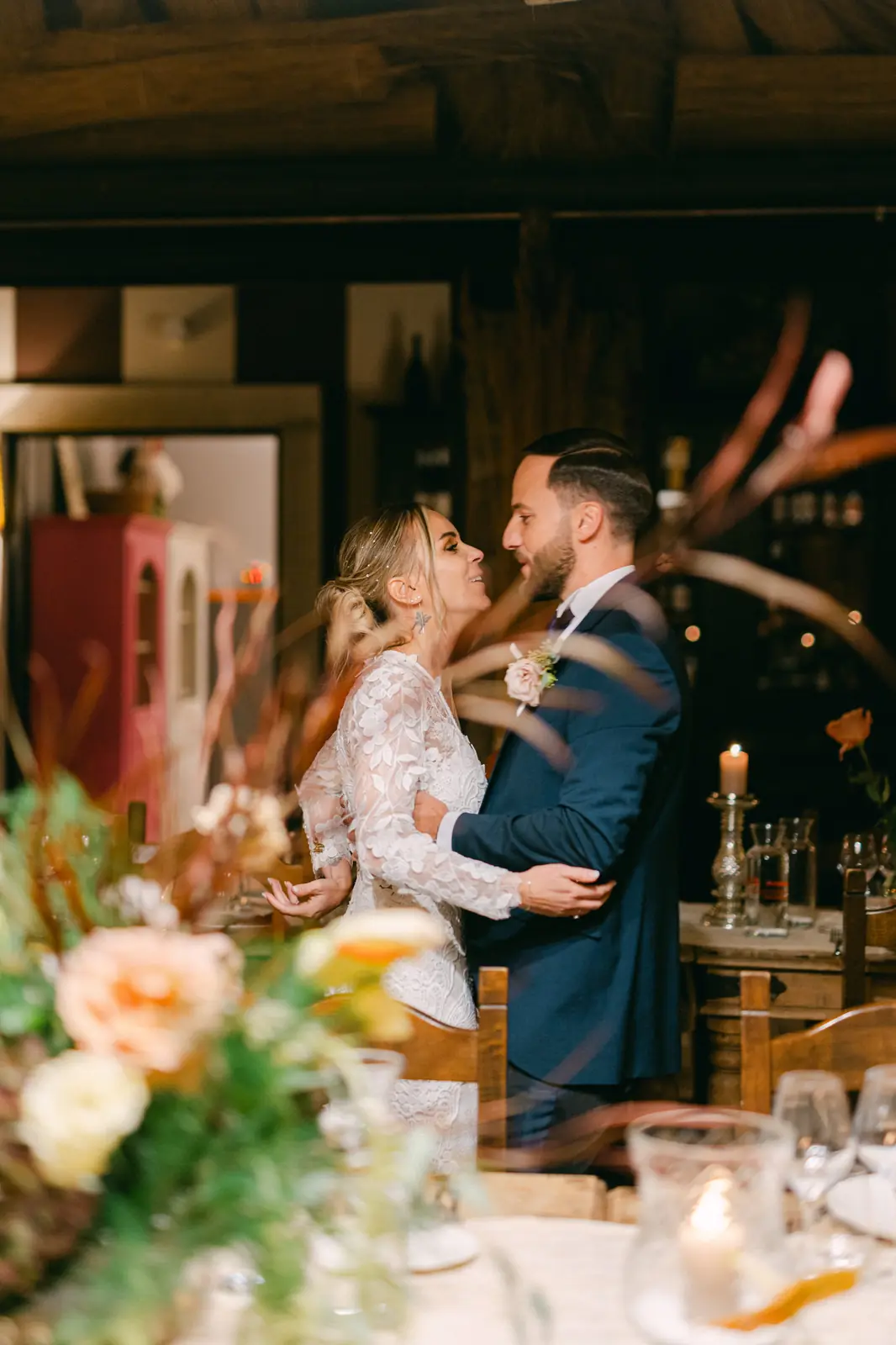 The couple embracing at the reception among the candles