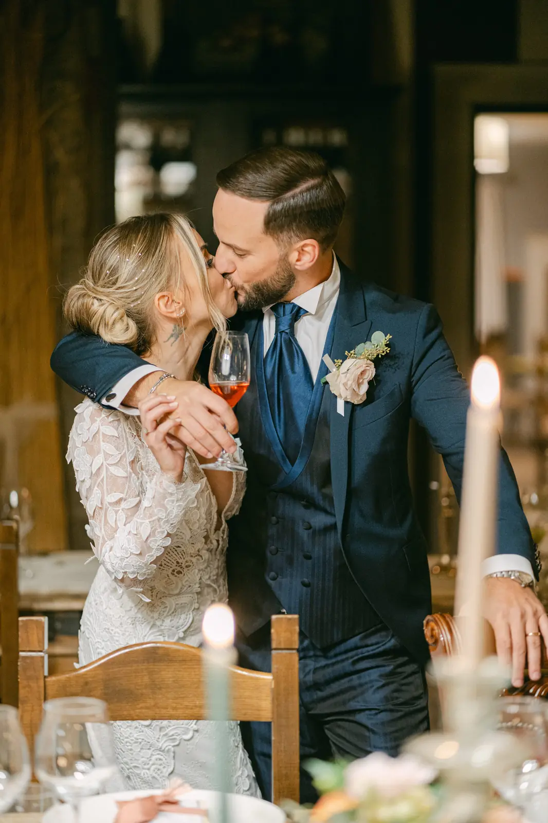 The couple kissing during a toast at the reception