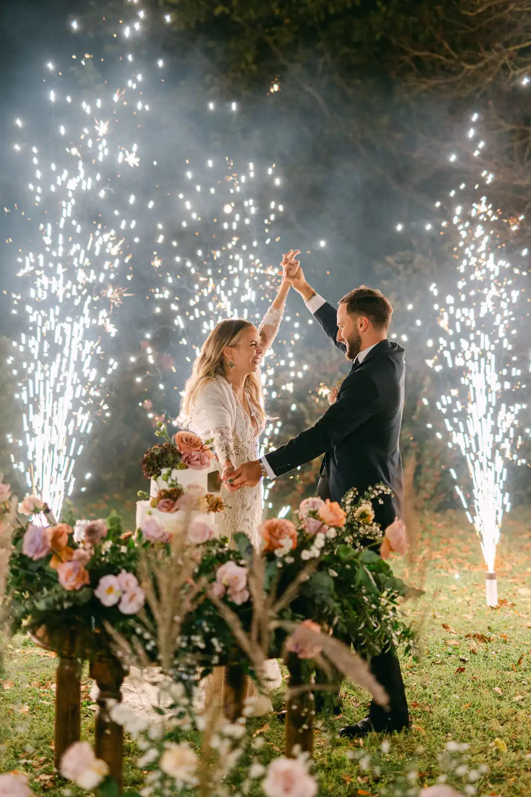 The wedding cake with sparkler fountains at night