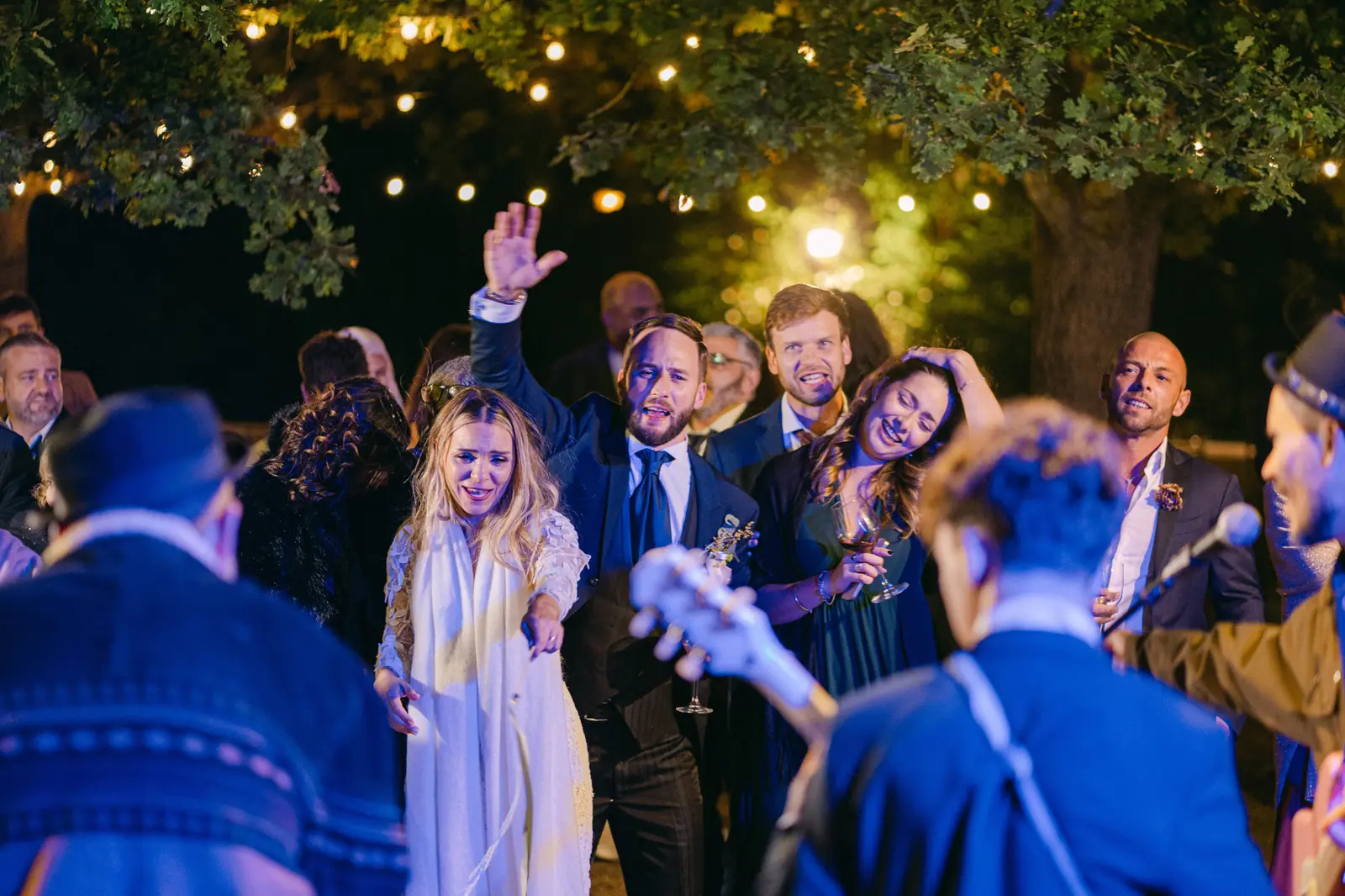 The evening party under the lights with the couple and guests