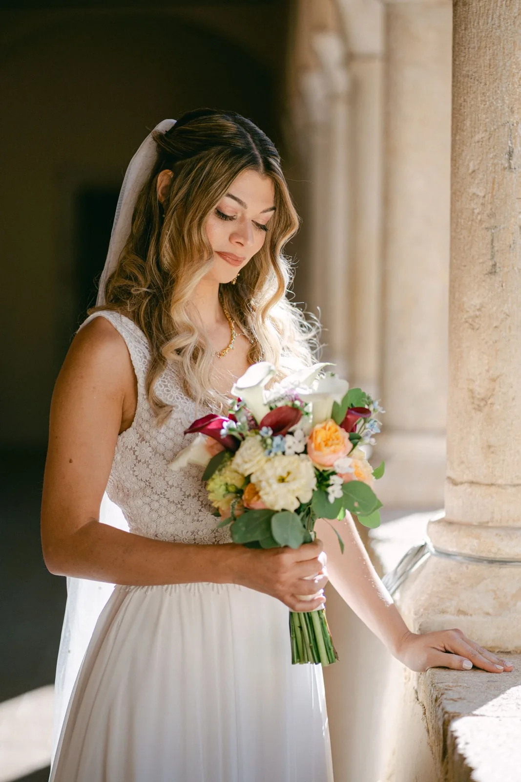 Julie con il bouquet sotto le arcate del chiostro dell’Abbazia San Pietro in Valle