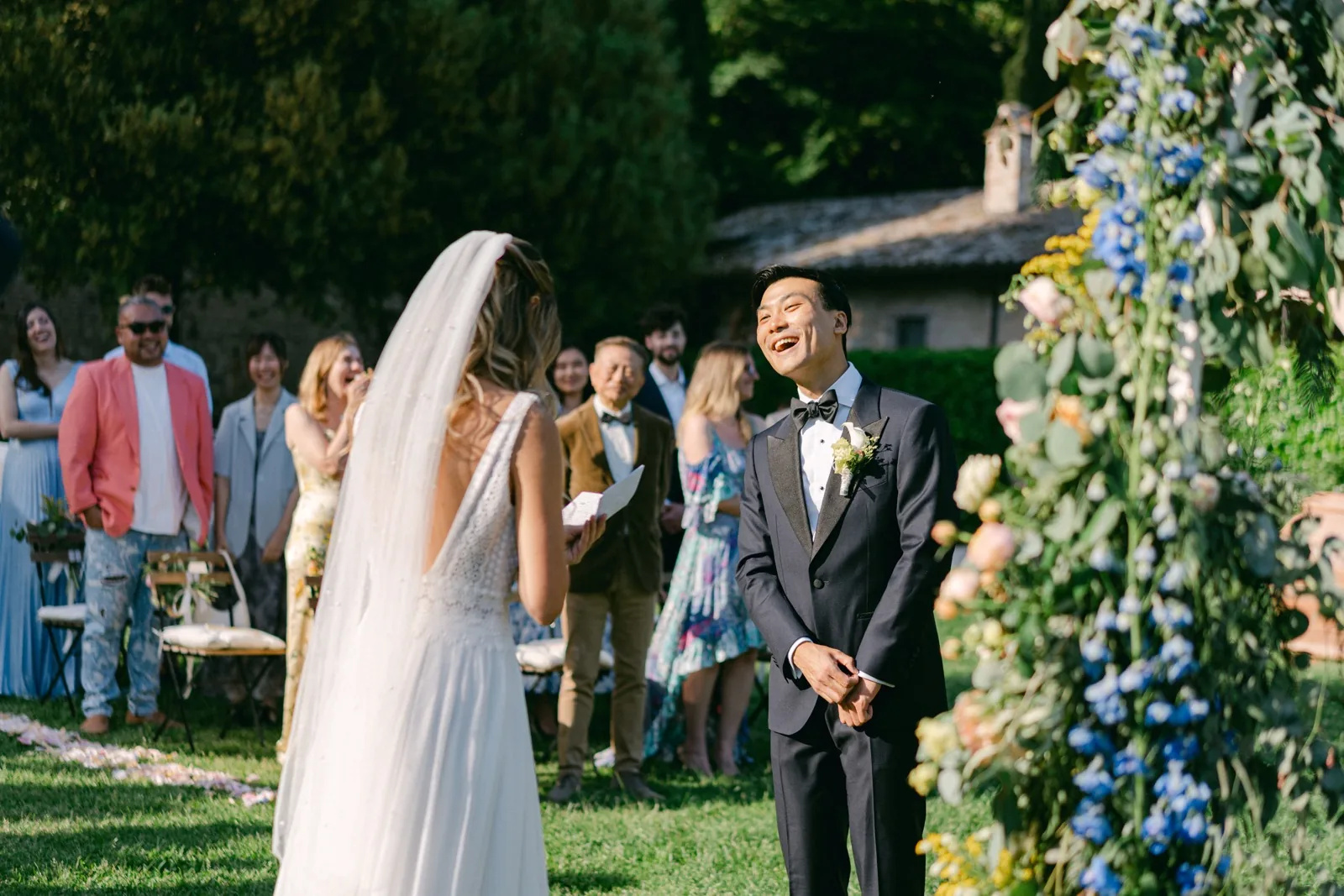 Gli invitati ridono durante la cerimonia nel giardino dell’abbazia