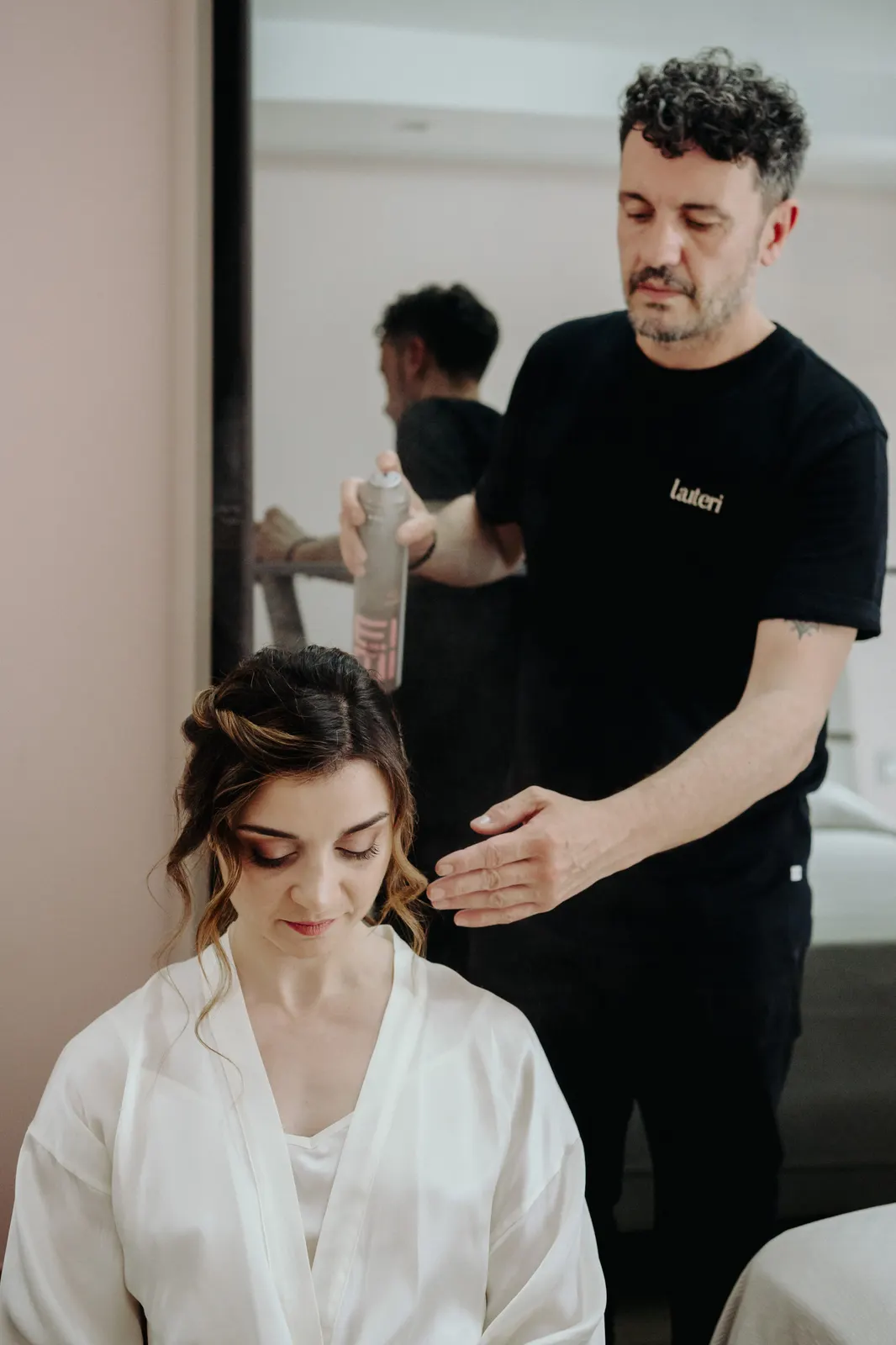 The hairdresser finishing Martina's hair while she gets ready