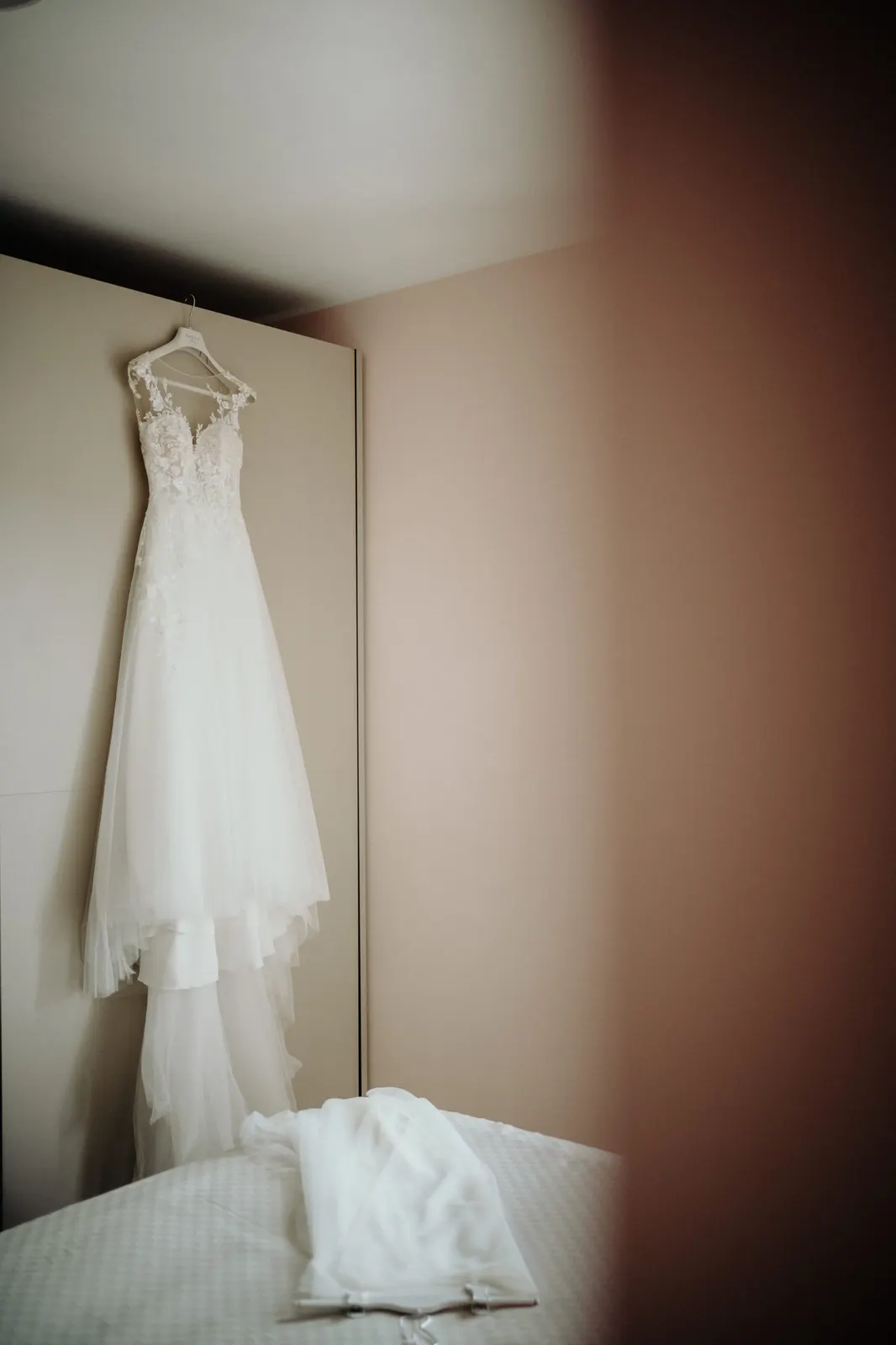 The wedding dress hanging in the bedroom before the bride puts it on