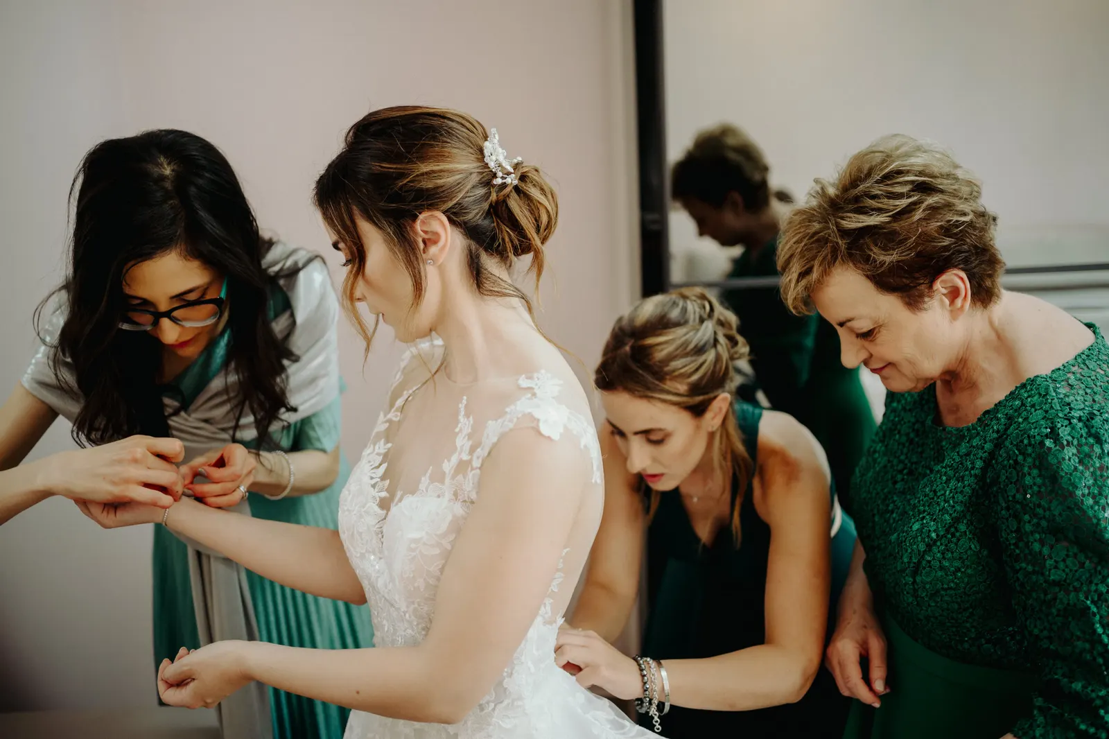 Martina being helped into her wedding dress by the women around her