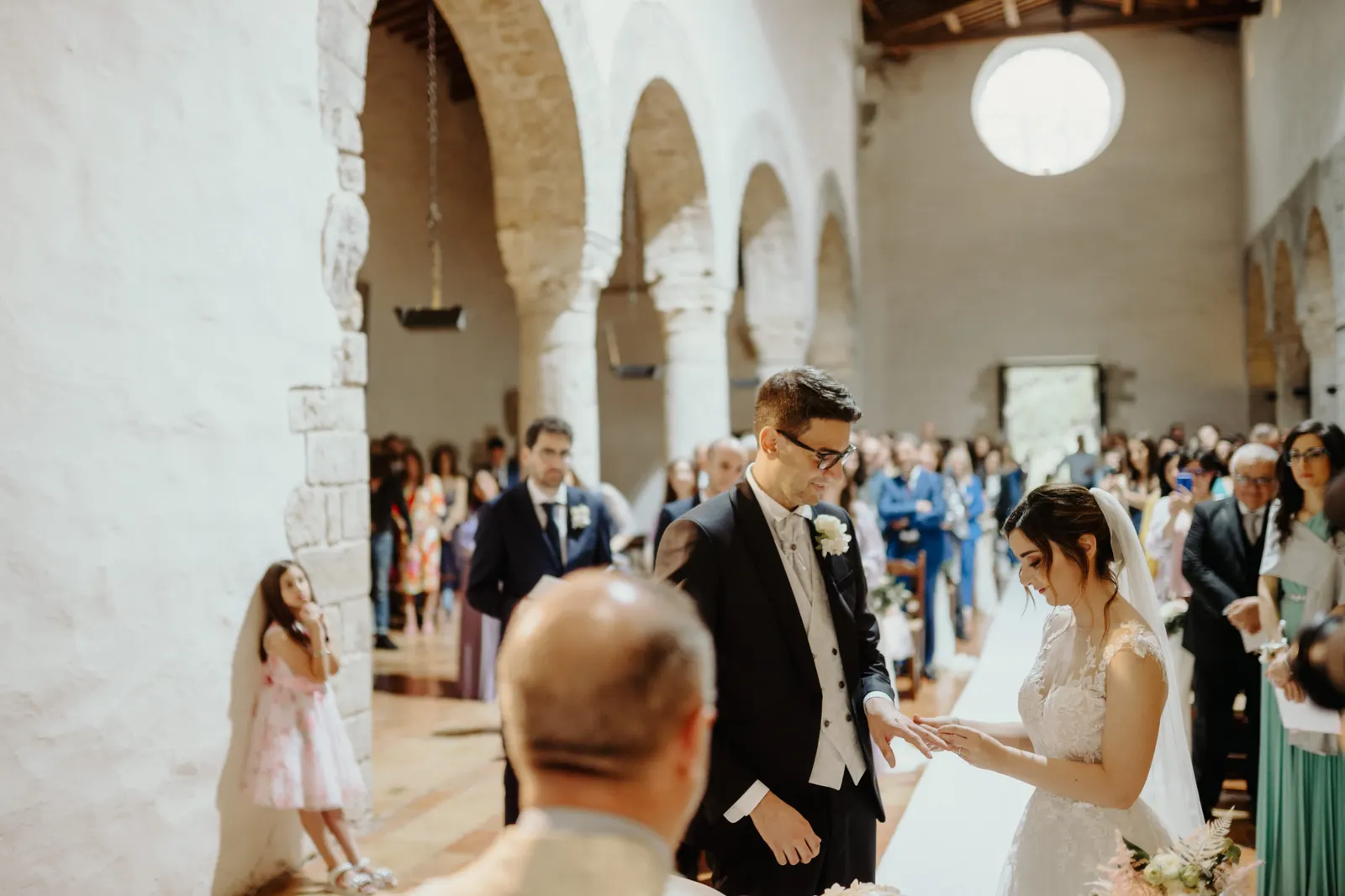 The exchange of rings among the stone arches of San Nicolò, with the guests behind