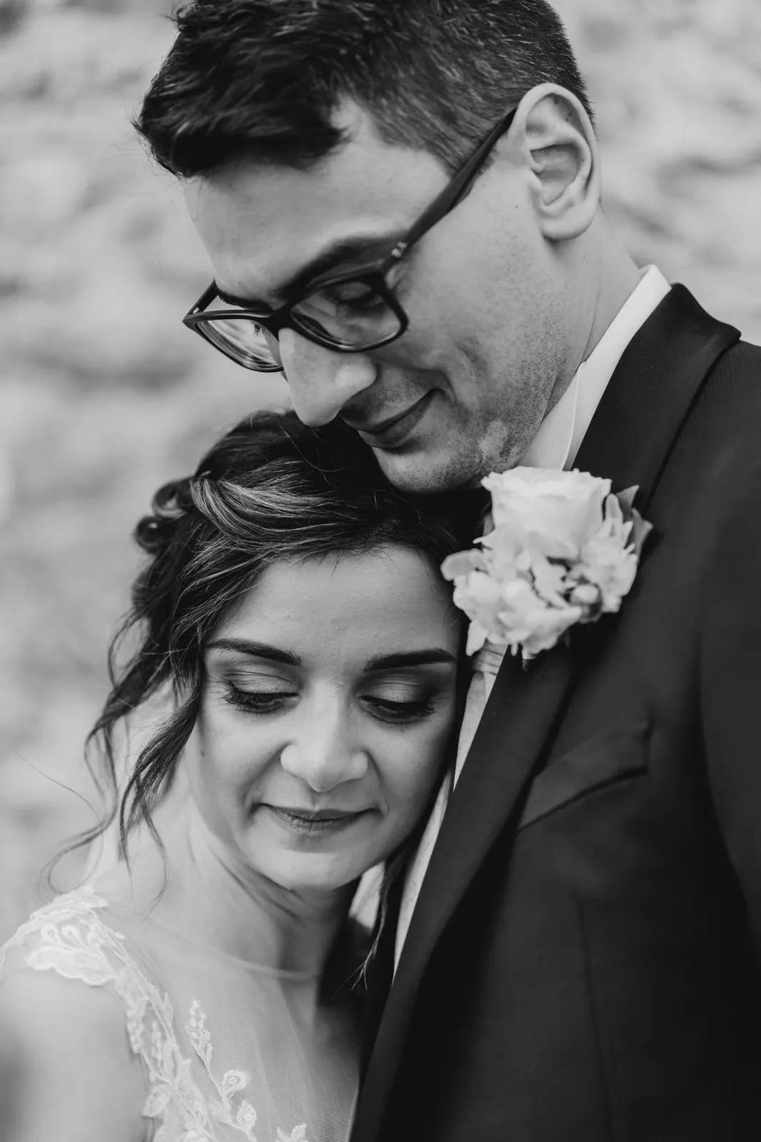 Daniele resting his face against Martina's hair, close portrait in black and white