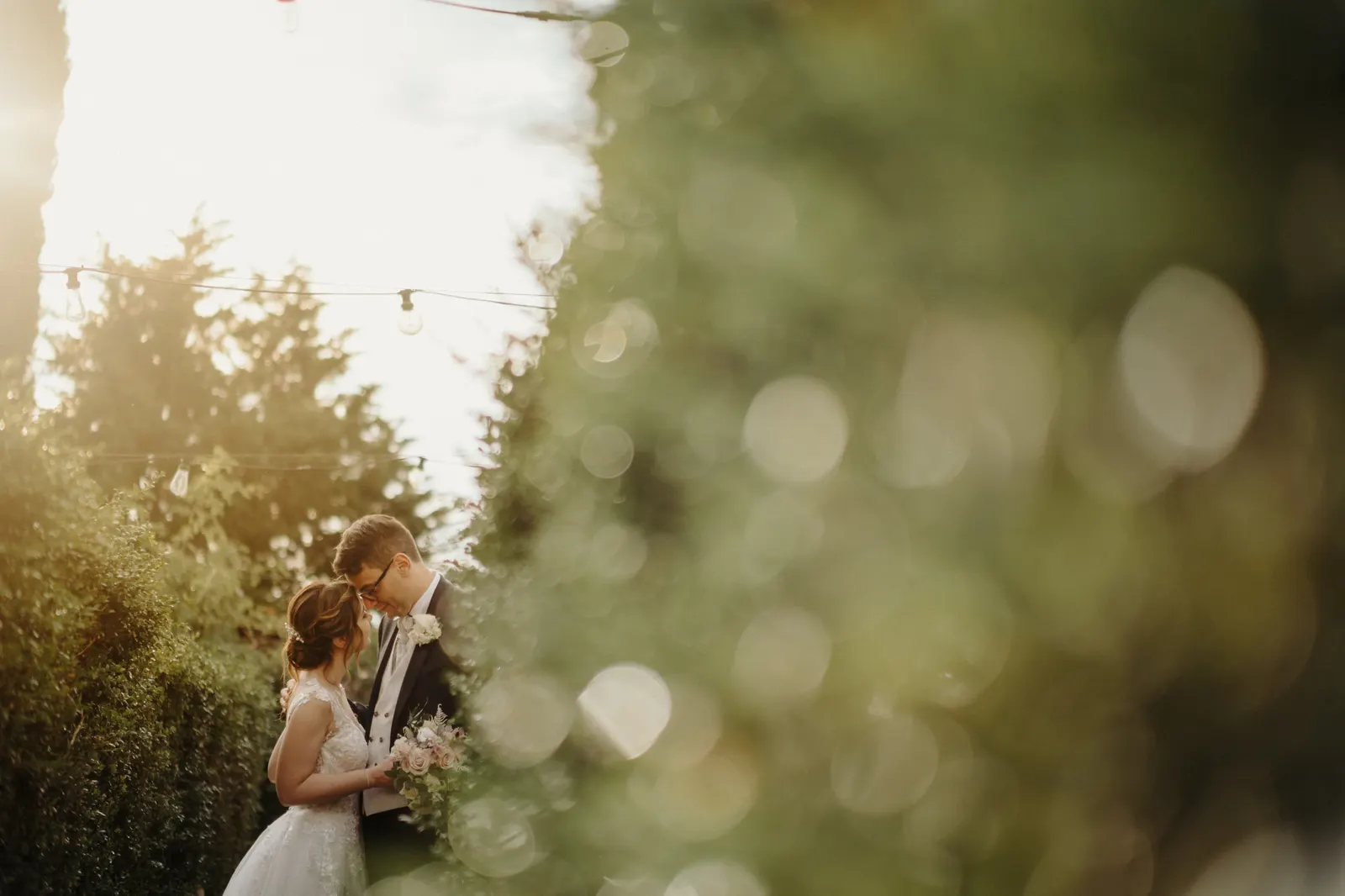 The couple kissing in backlight among the greenery of Castello di Montignano
