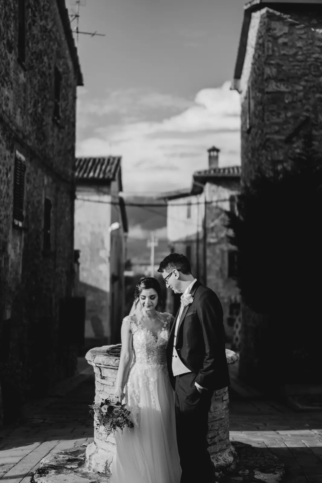 Martina and Daniele in a lane of the hamlet, with the hills behind, in black and white