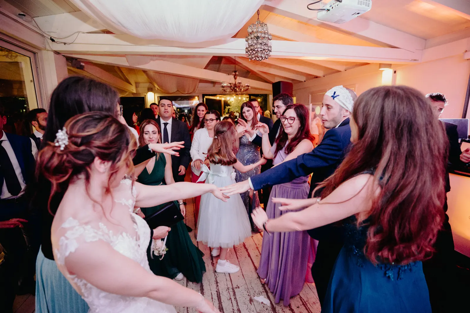 The bride dancing in a circle with the guests during the party