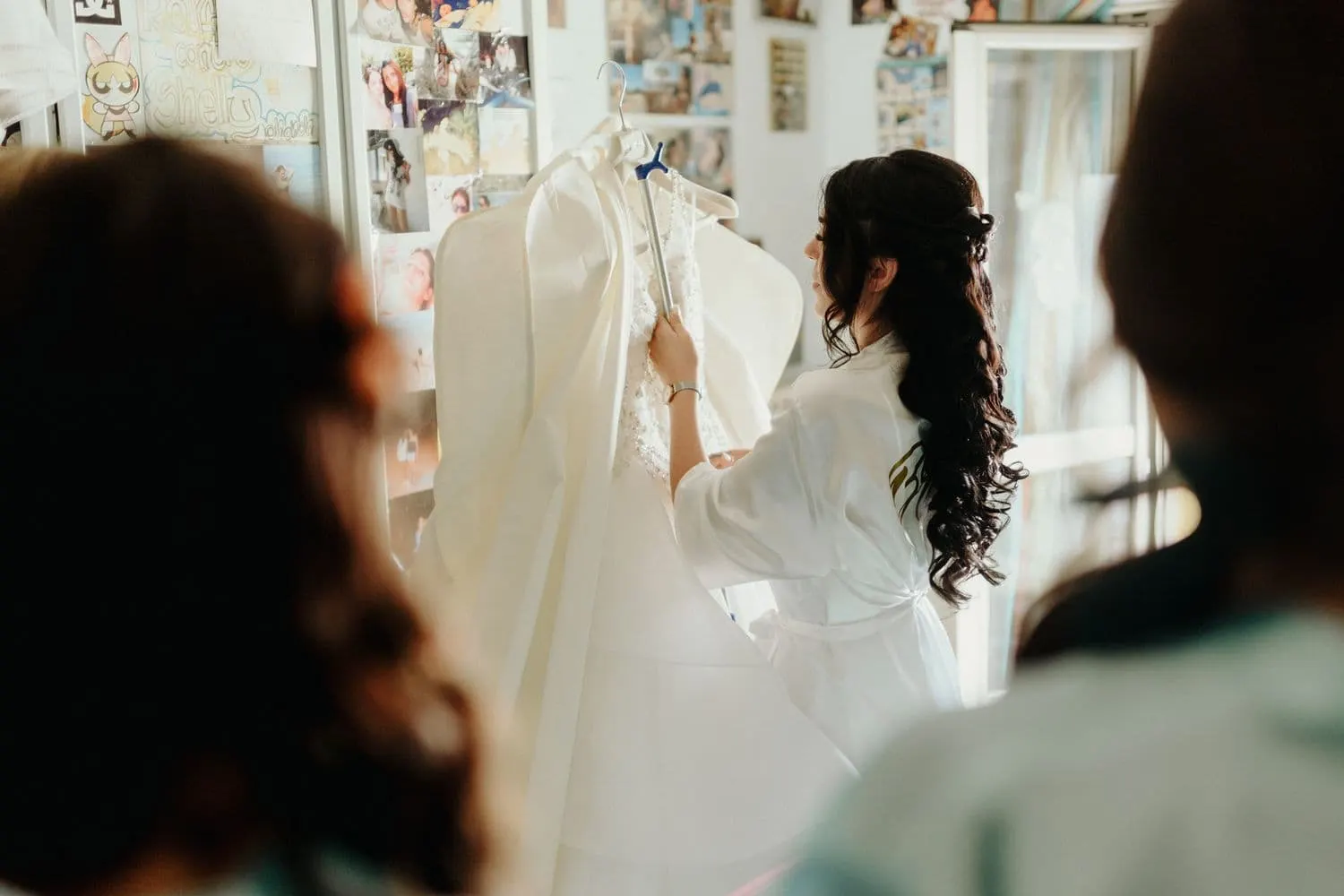 La sposa davanti all'abito appeso nella sua stanza