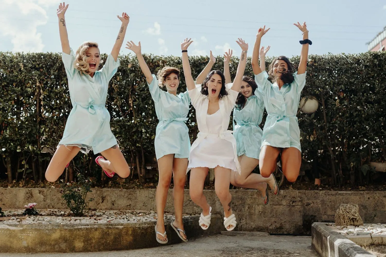 Micaela and her friends all jumping together in the garden