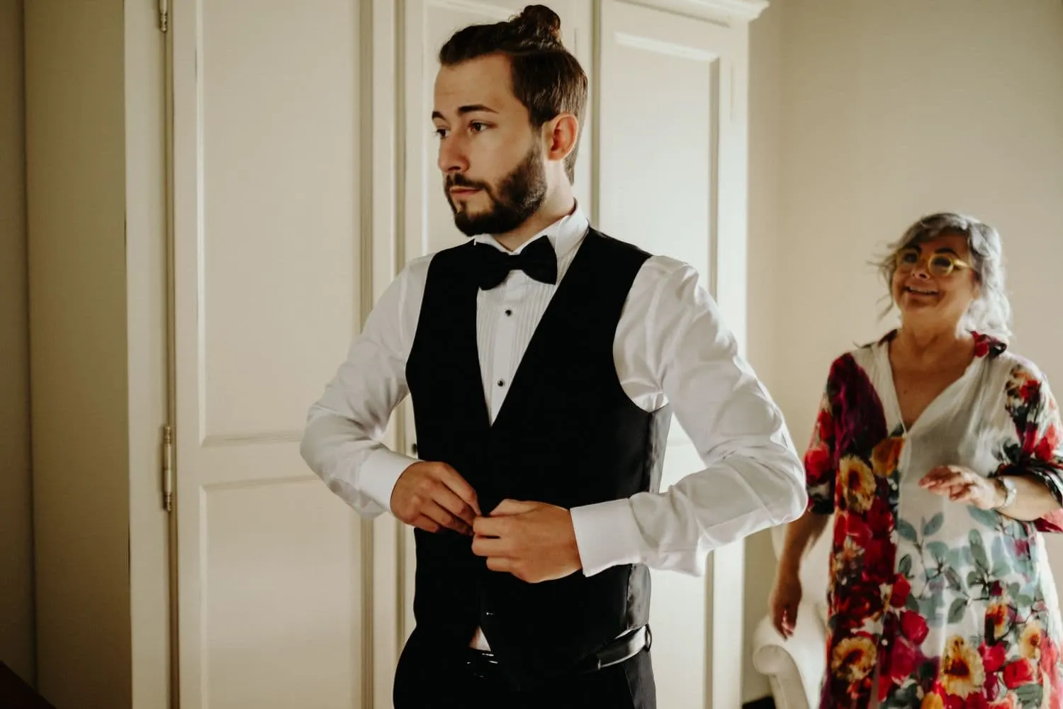 Raffaele si abbottona il gilet durante i preparativi