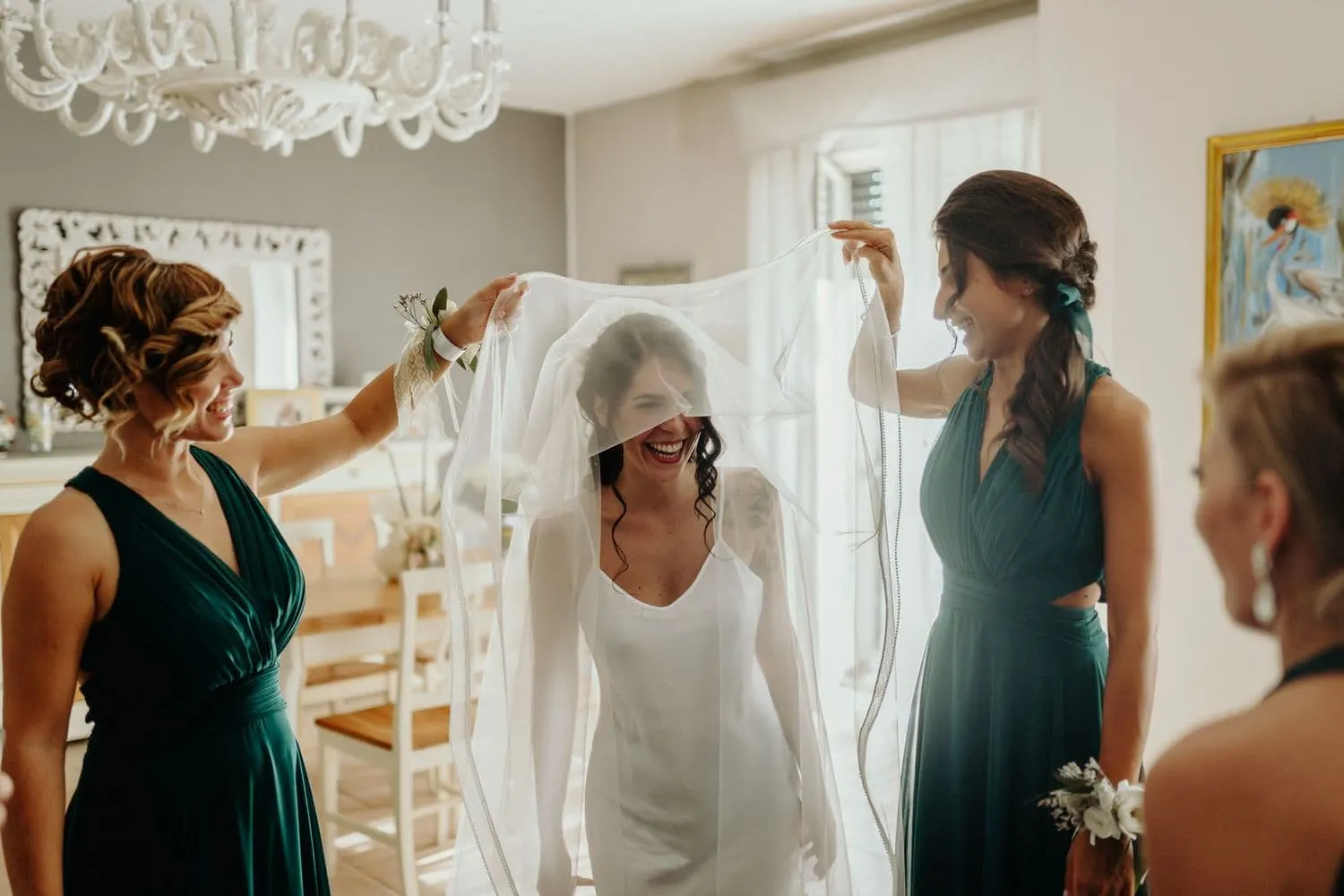 Le damigelle sistemano il velo sulla testa della sposa