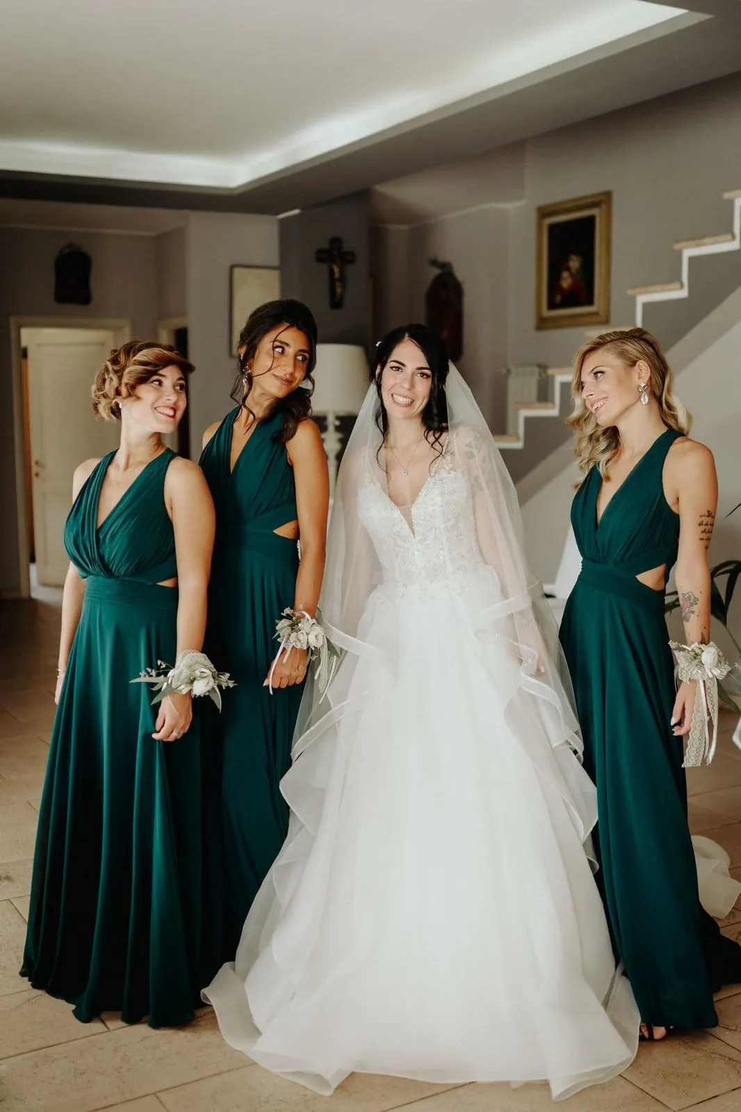 Micaela in abito da sposa tra le damigelle vestite di verde bosco
