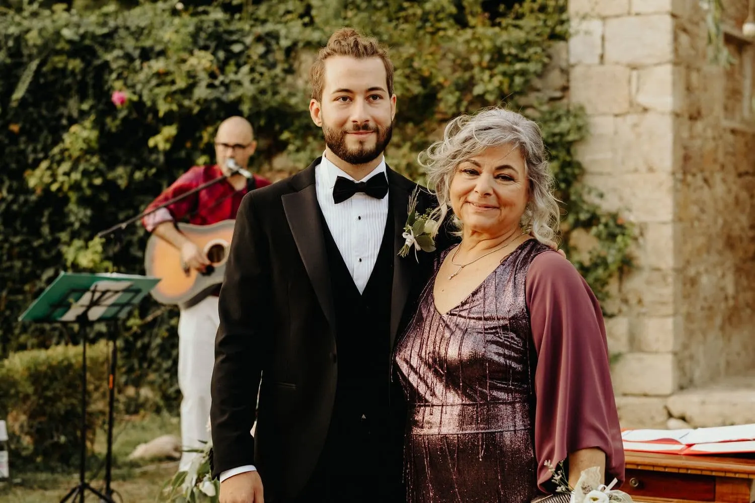 Raffaele e la madre aspettano la sposa, con il chitarrista alle spalle