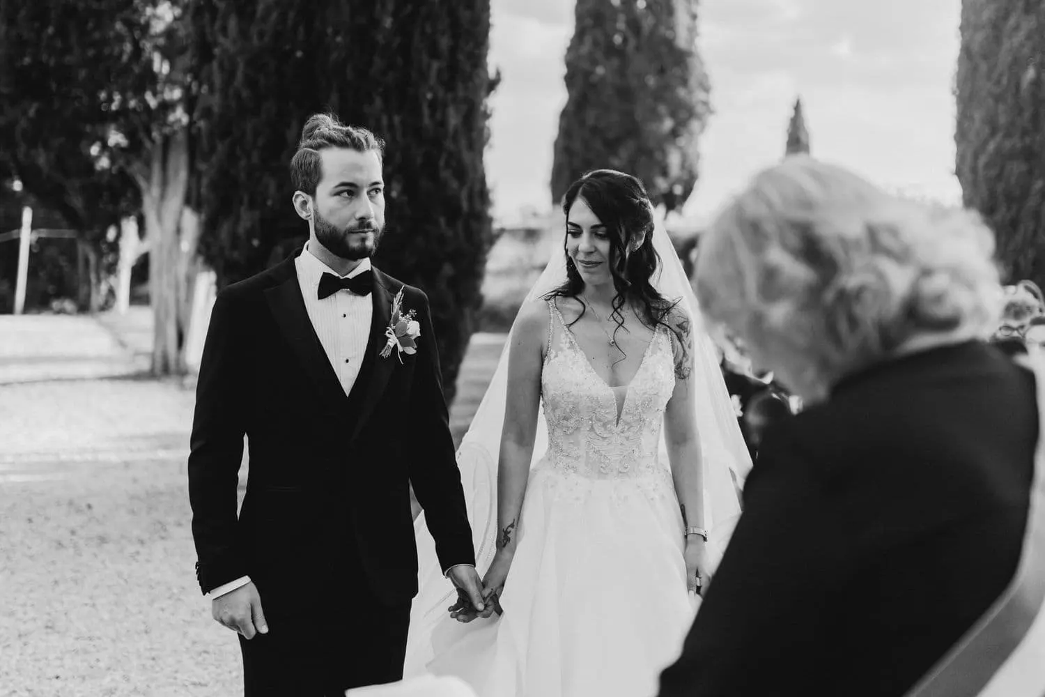 Gli sposi mano nella mano durante il rito civile, in bianco e nero