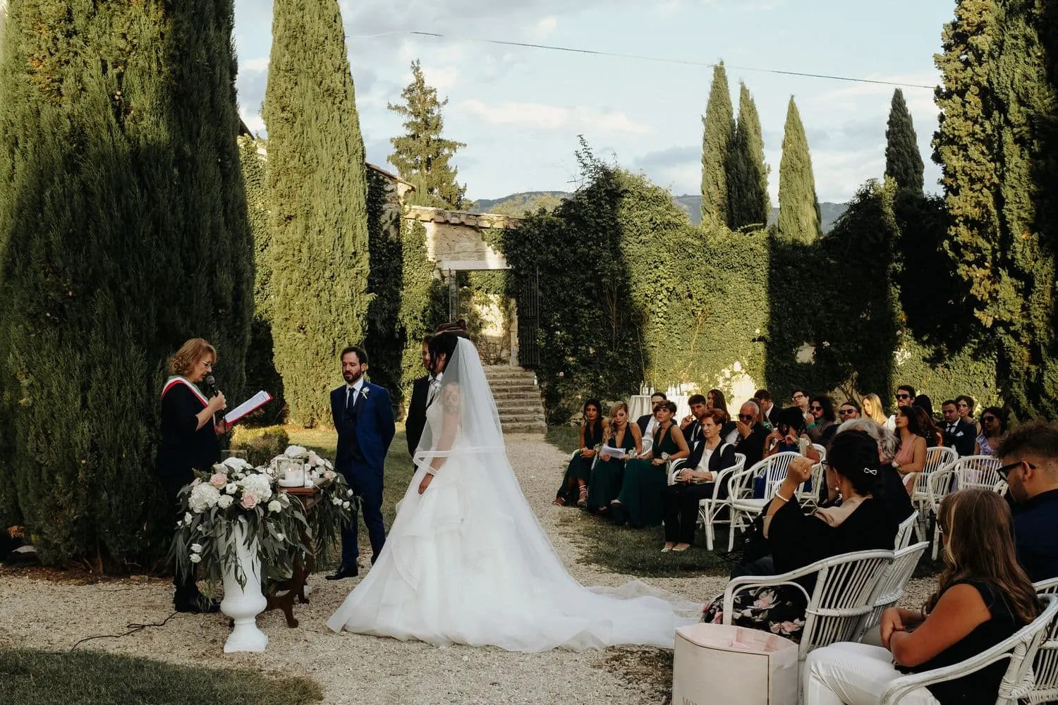 Il rito civile nello spiazzo tra i cipressi, con gli invitati seduti