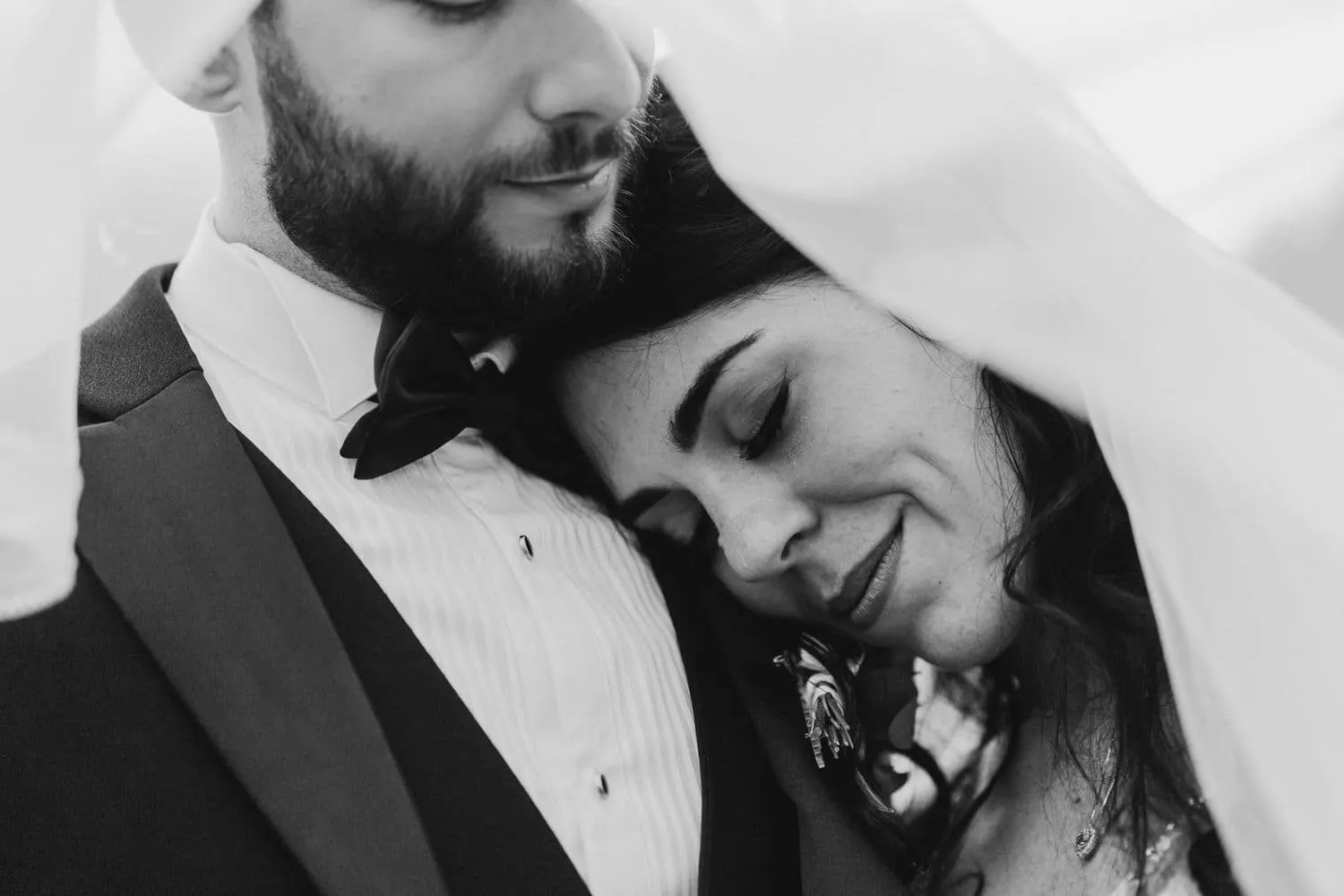 Micaela appoggiata al petto di Raffaele sotto il velo, in bianco e nero