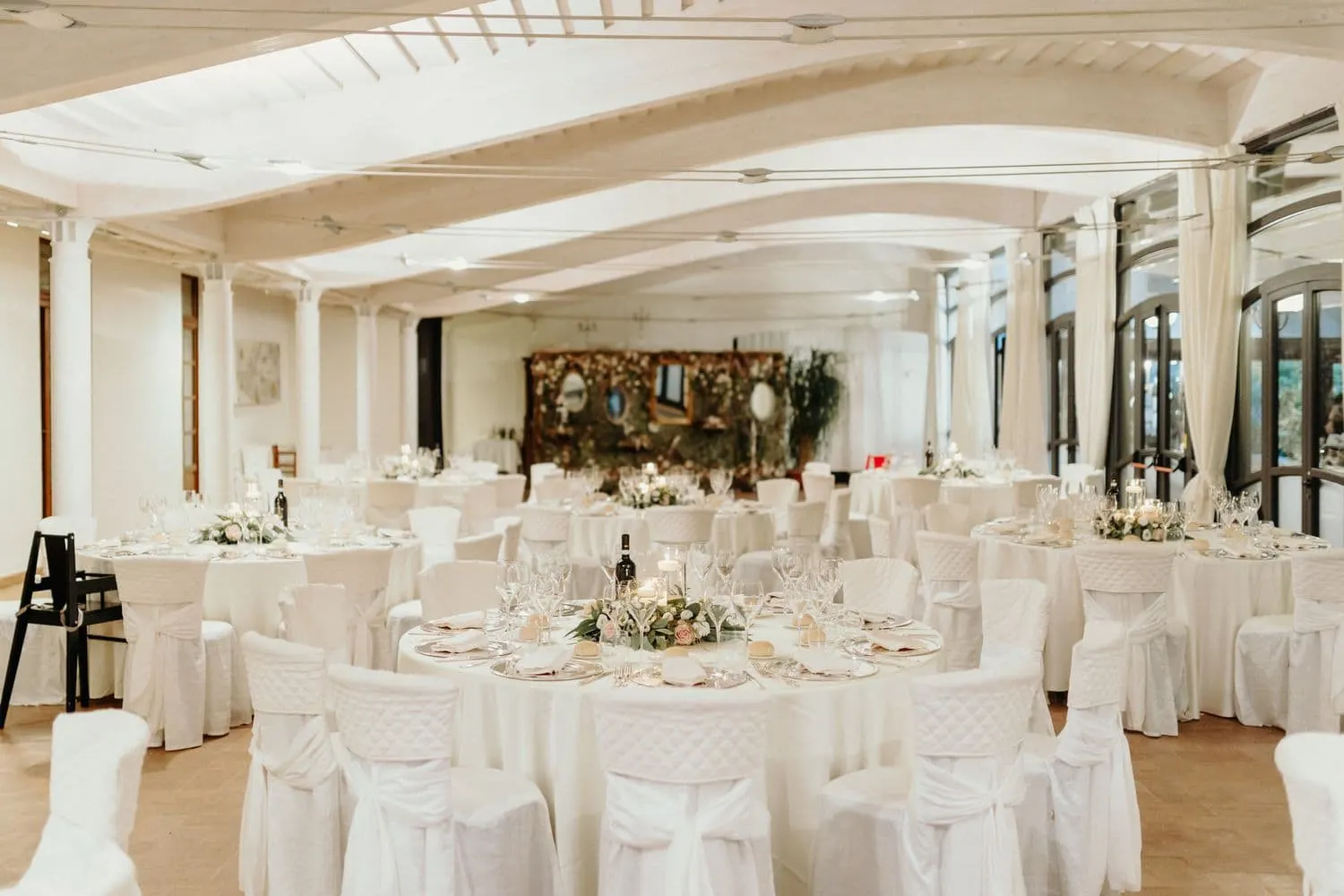 La sala del ricevimento con i tavoli rotondi apparecchiati di bianco