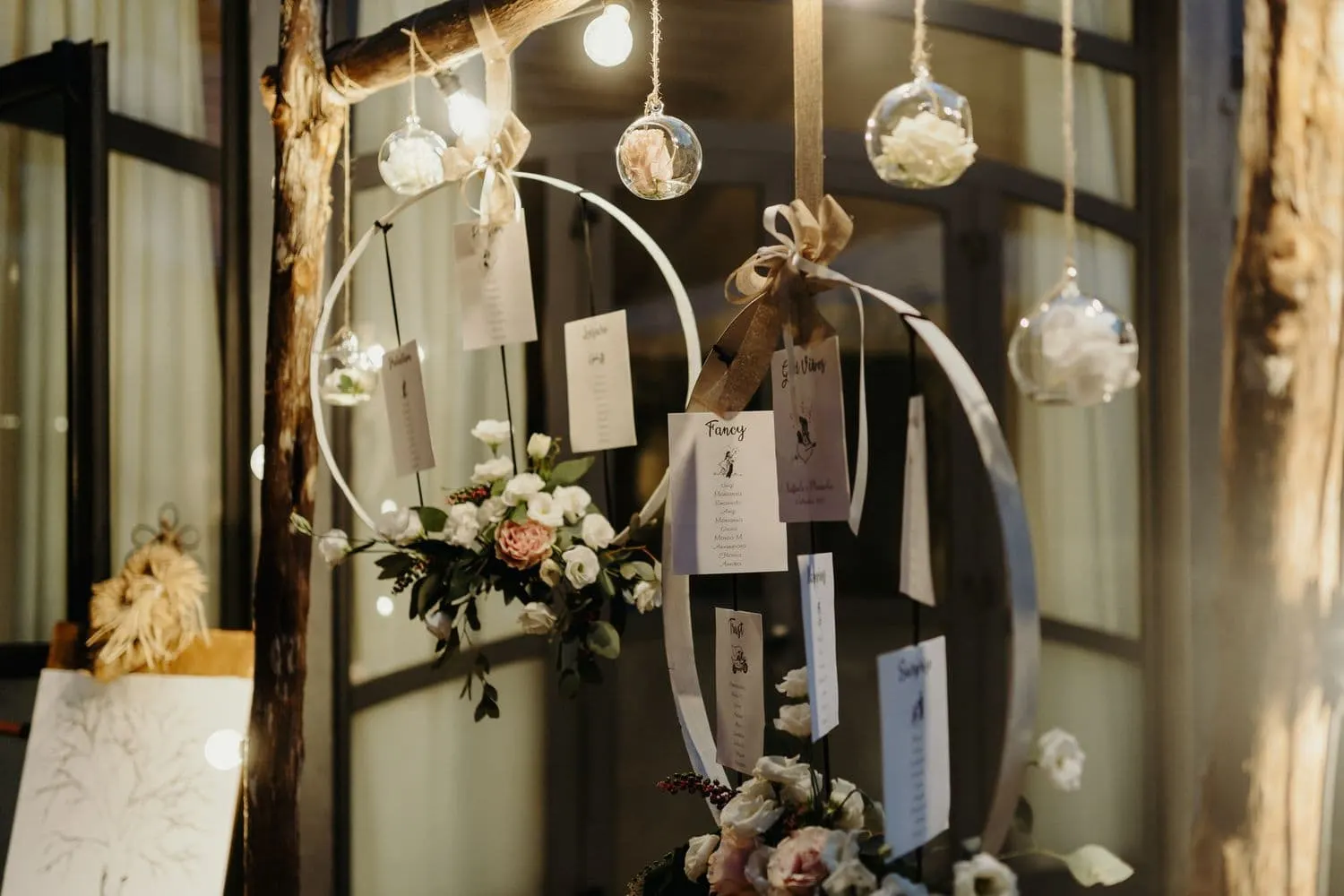Dettaglio del tableau de mariage con fiori e lampadine sospese