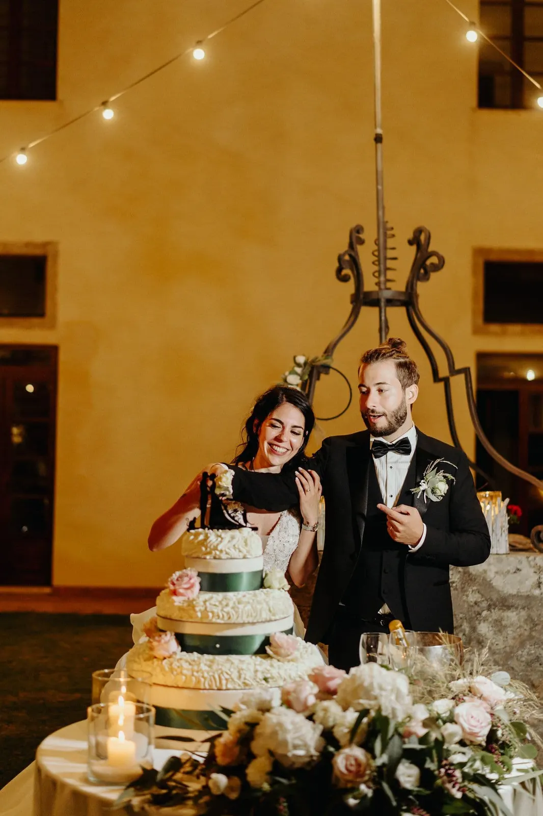 Il taglio della torta all'aperto sotto il cielo stellato di luci