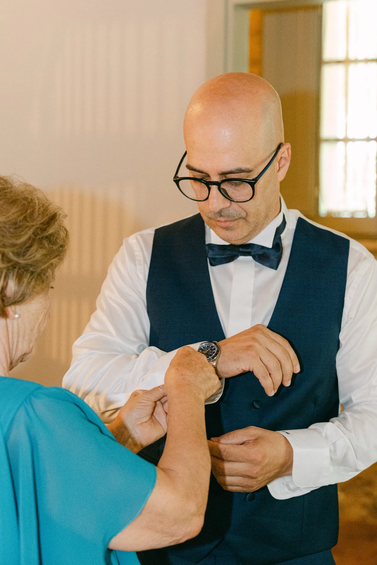 Tonino in gilet e papillon mentre gli allacciano il polsino