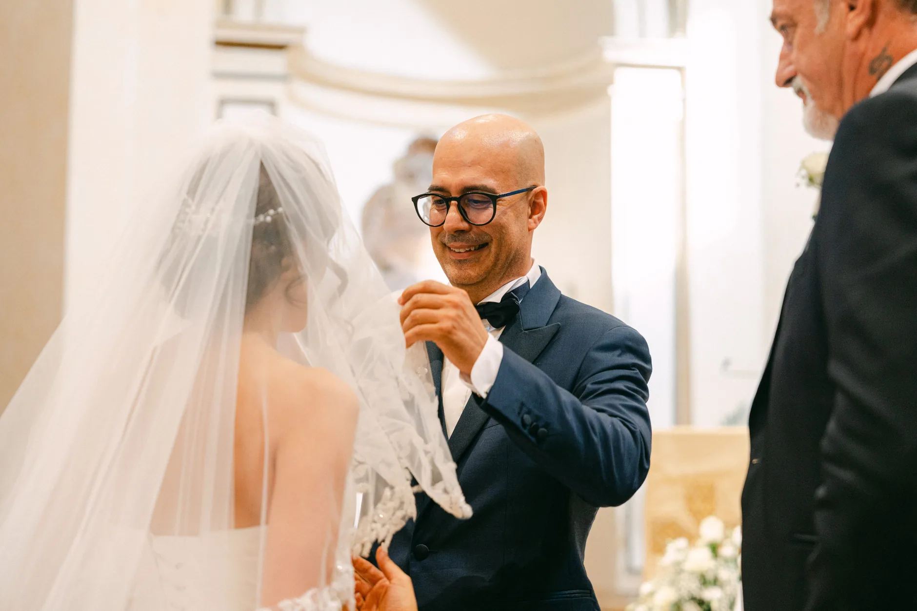 Tonino sorride mentre solleva il velo di Rossella all'altare