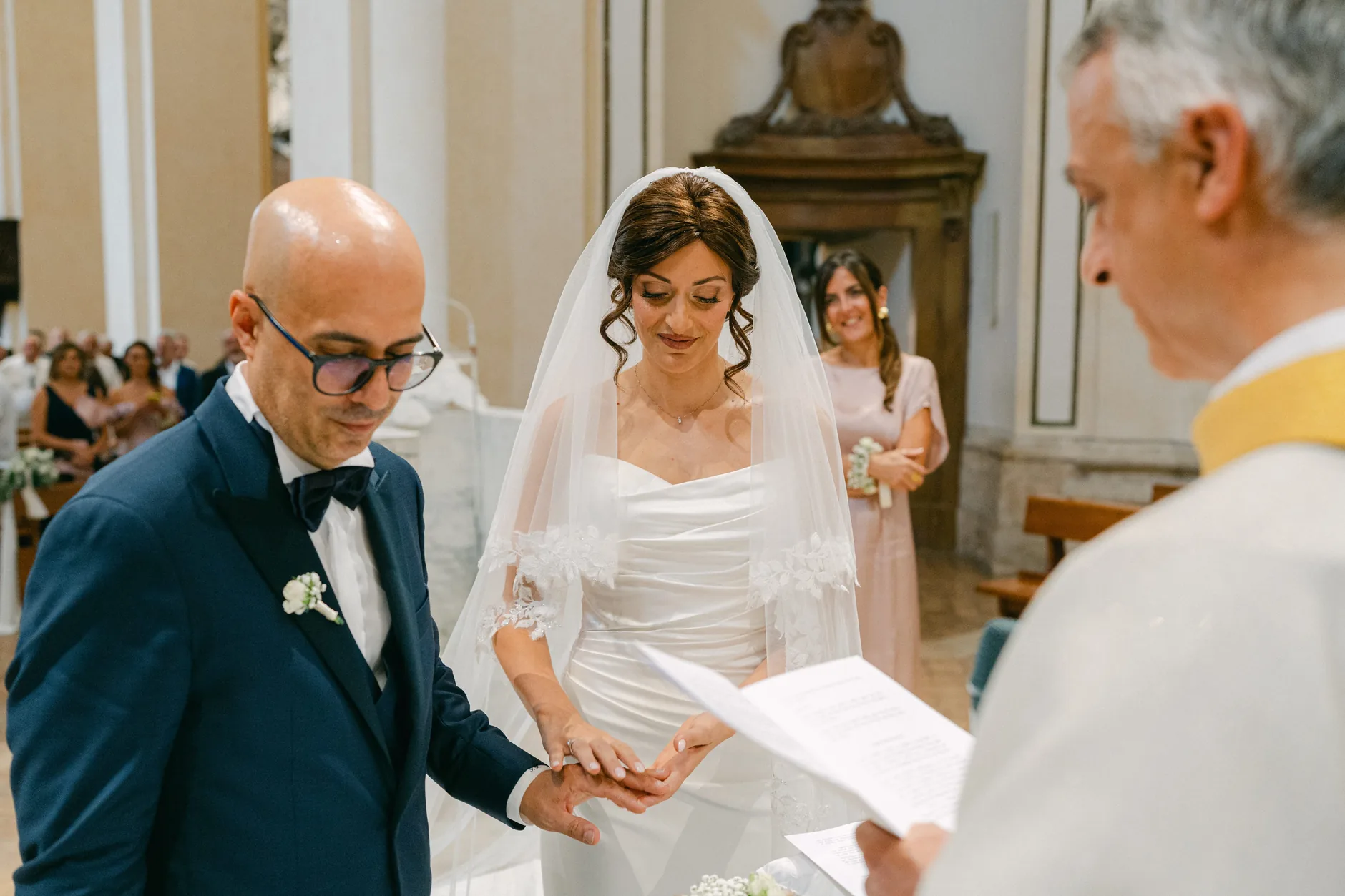 Rossella infila la fede al dito di Tonino davanti al sacerdote