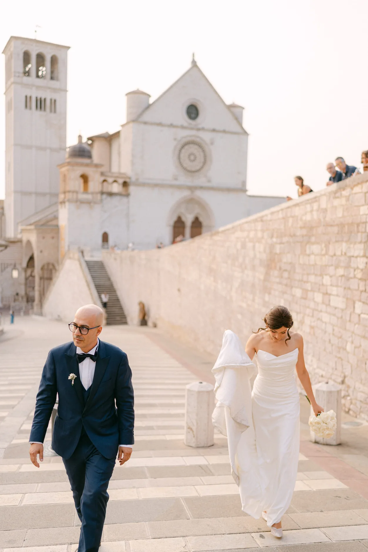 Rossella e Tonino scendono dalla Basilica di San Francesco, con la facciata sullo sfondo