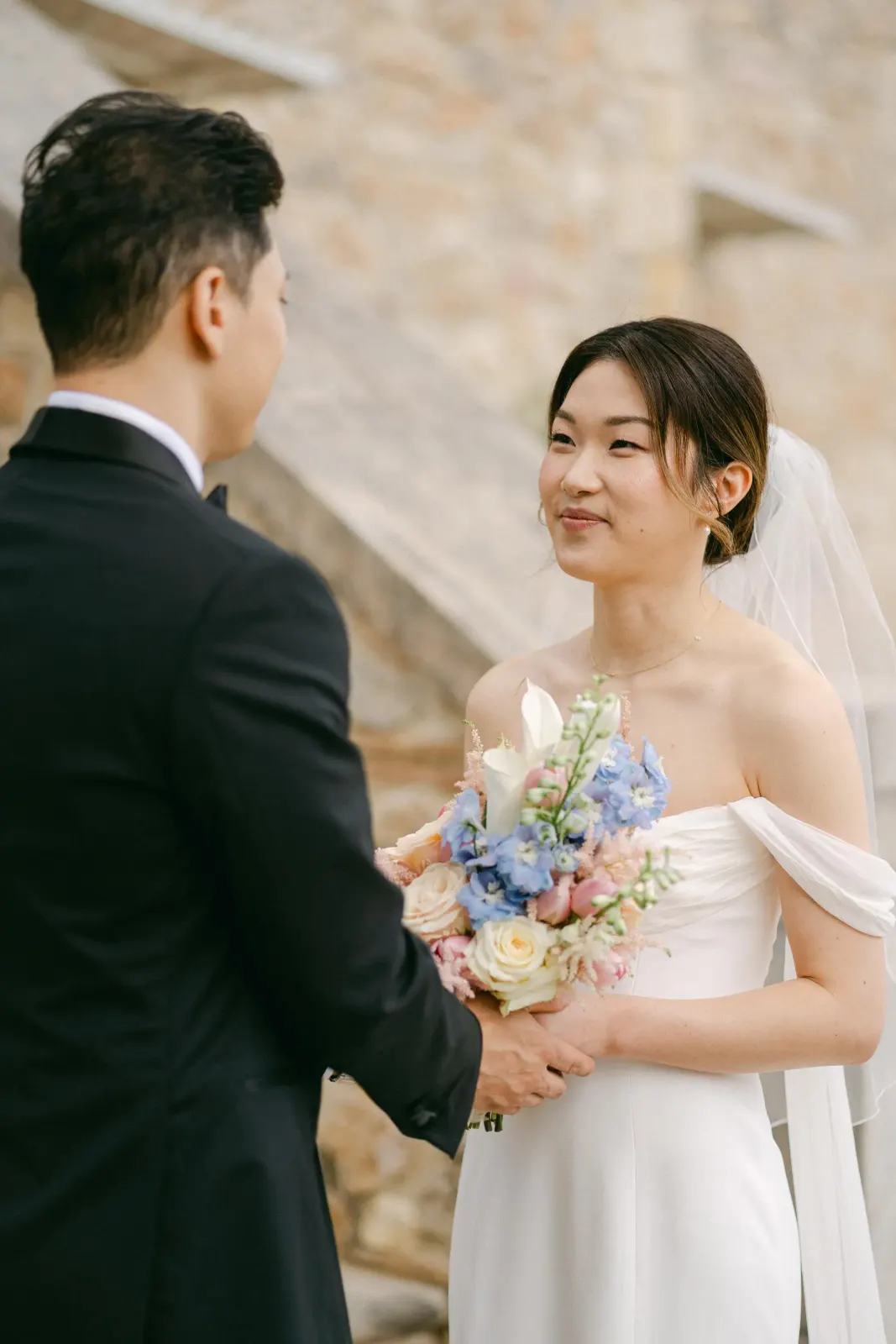 Audrey smiling at James during the first look, bouquet in her hands