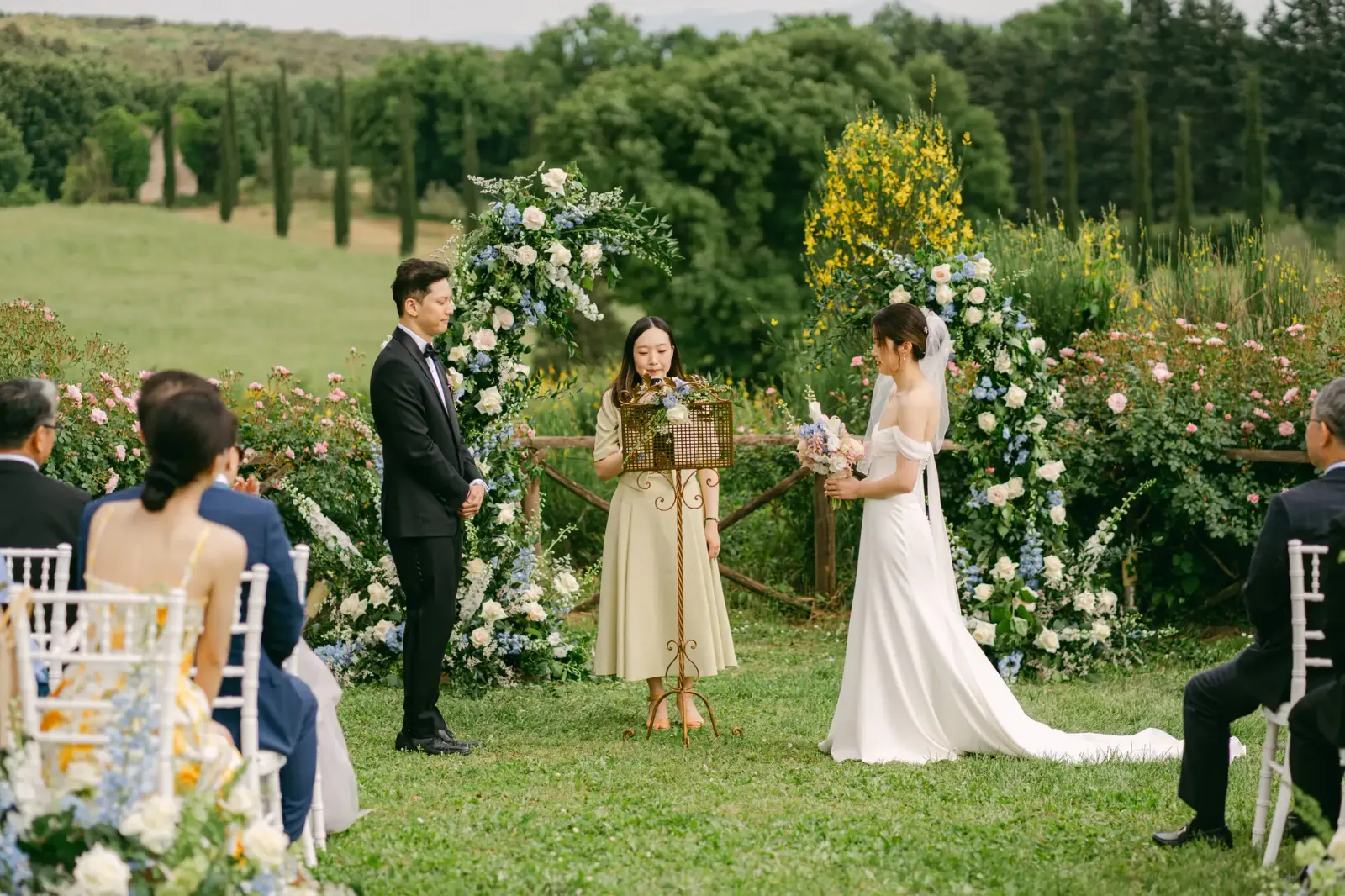 The garden ceremony in front of the floral arch, with the countryside of Amelia behind