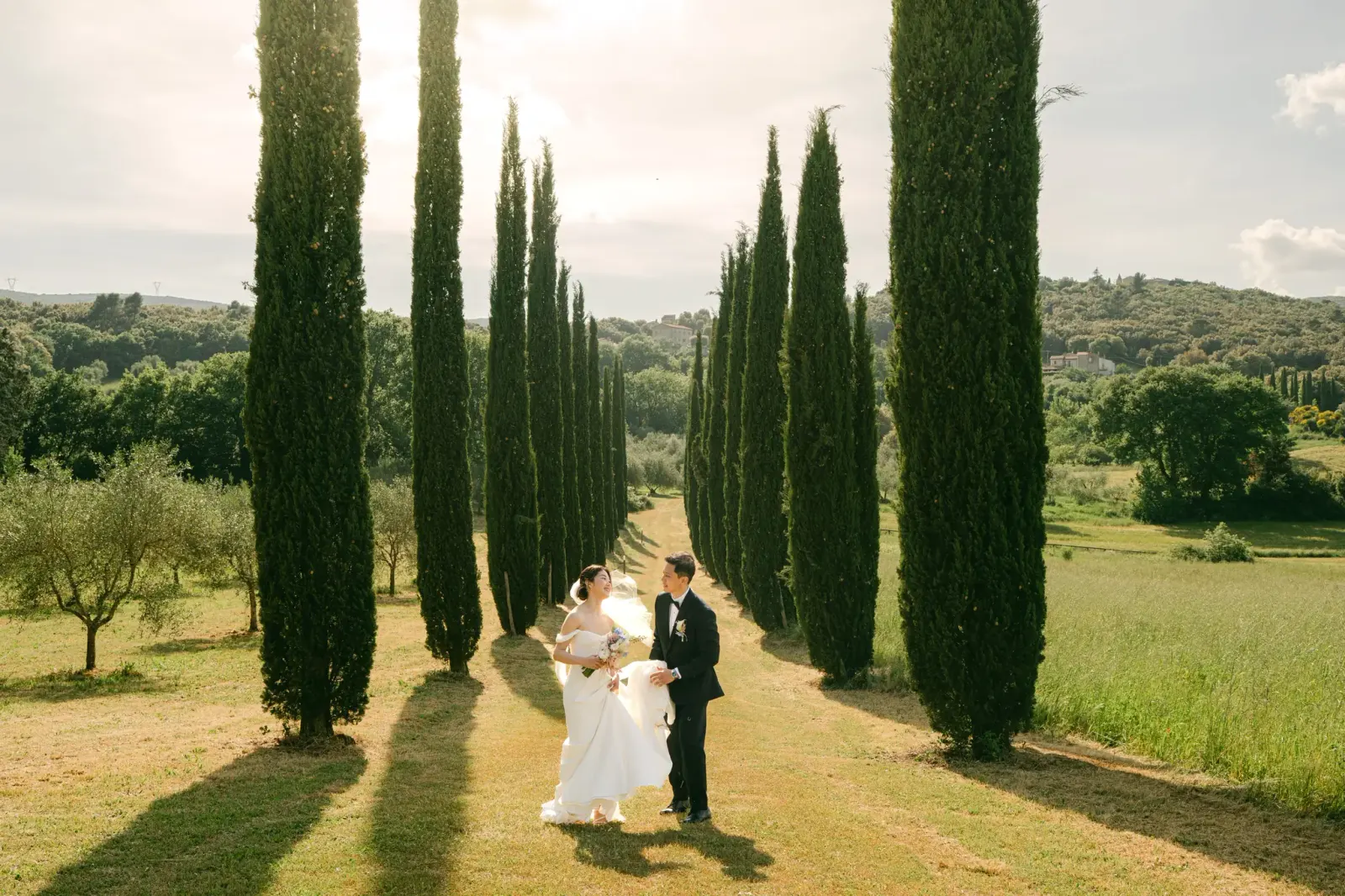 Audrey and James in the cypress avenue, with the Umbrian countryside around them