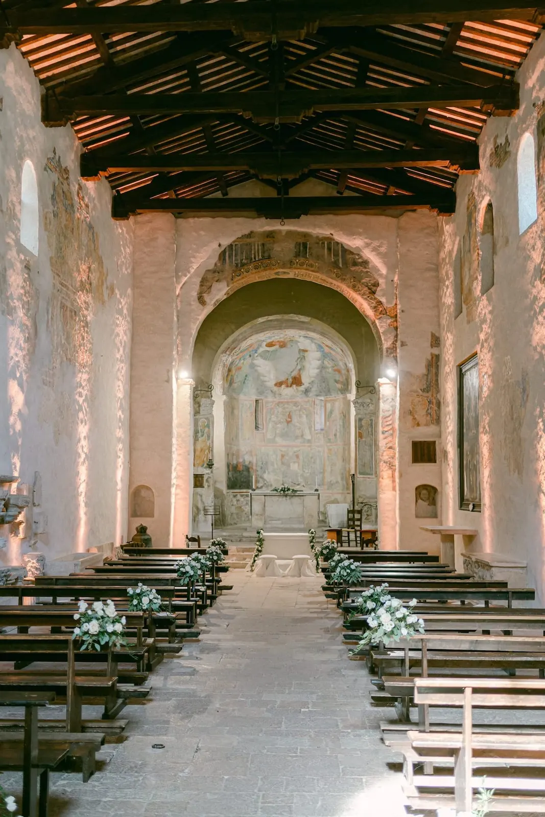 La navata della chiesa con le capriate in legno e gli affreschi alle pareti