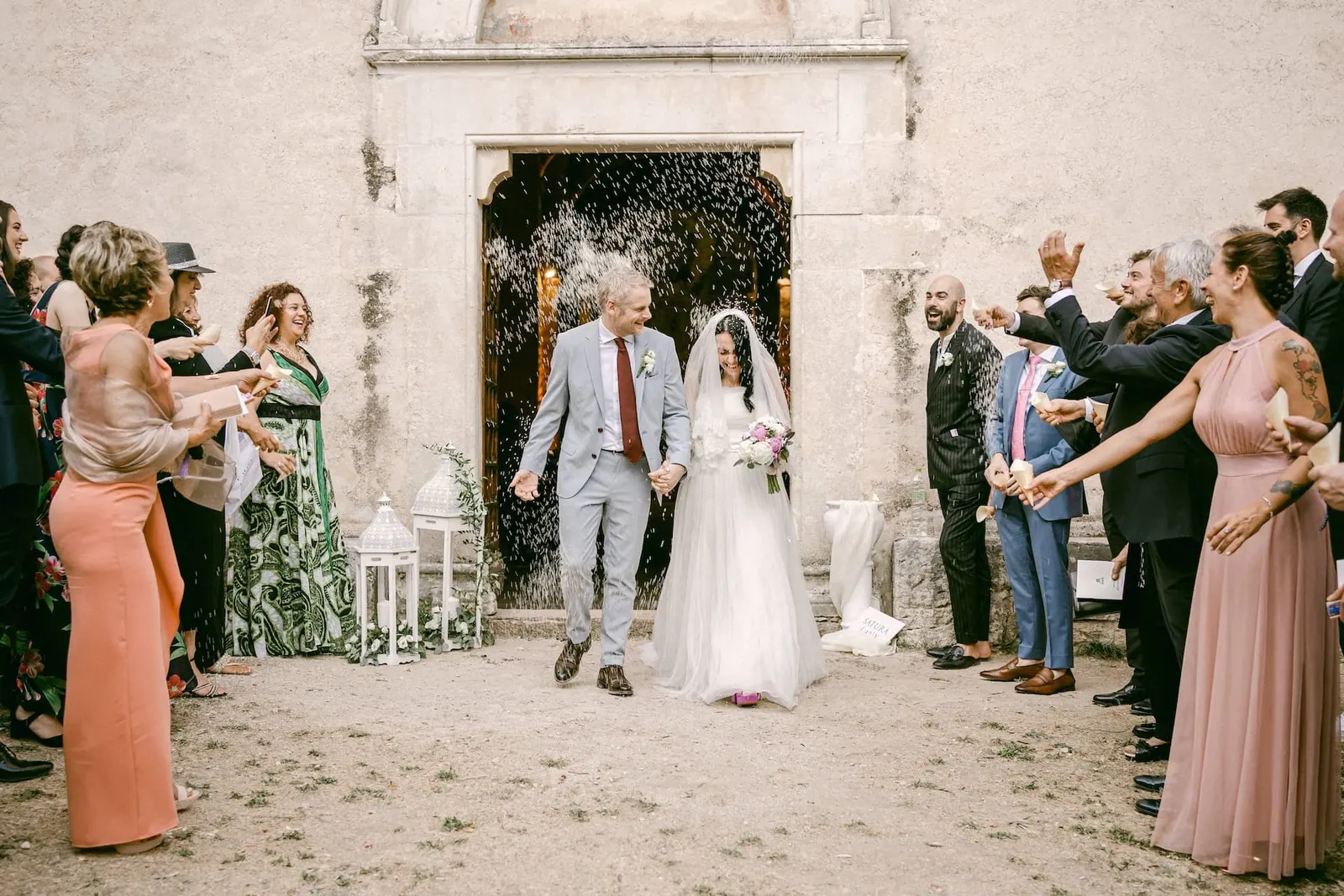 L'uscita degli sposi dalla chiesa tra il lancio di riso e gli invitati