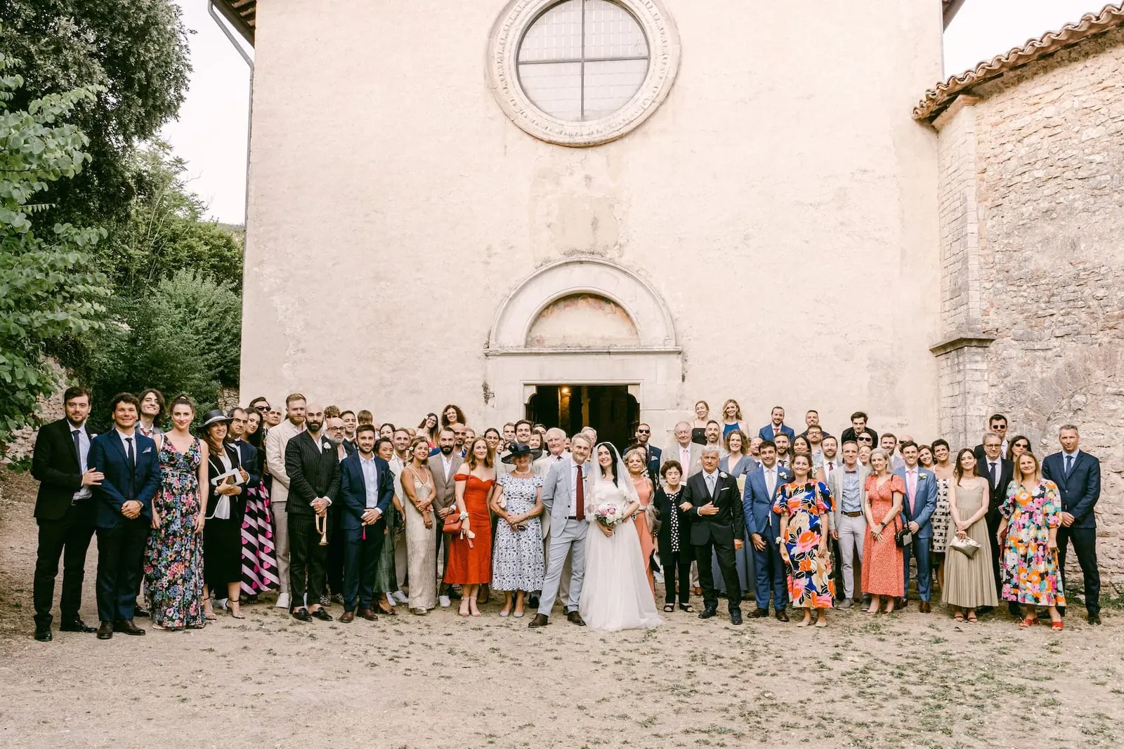 La foto di gruppo con tutti gli invitati davanti alla facciata della chiesa