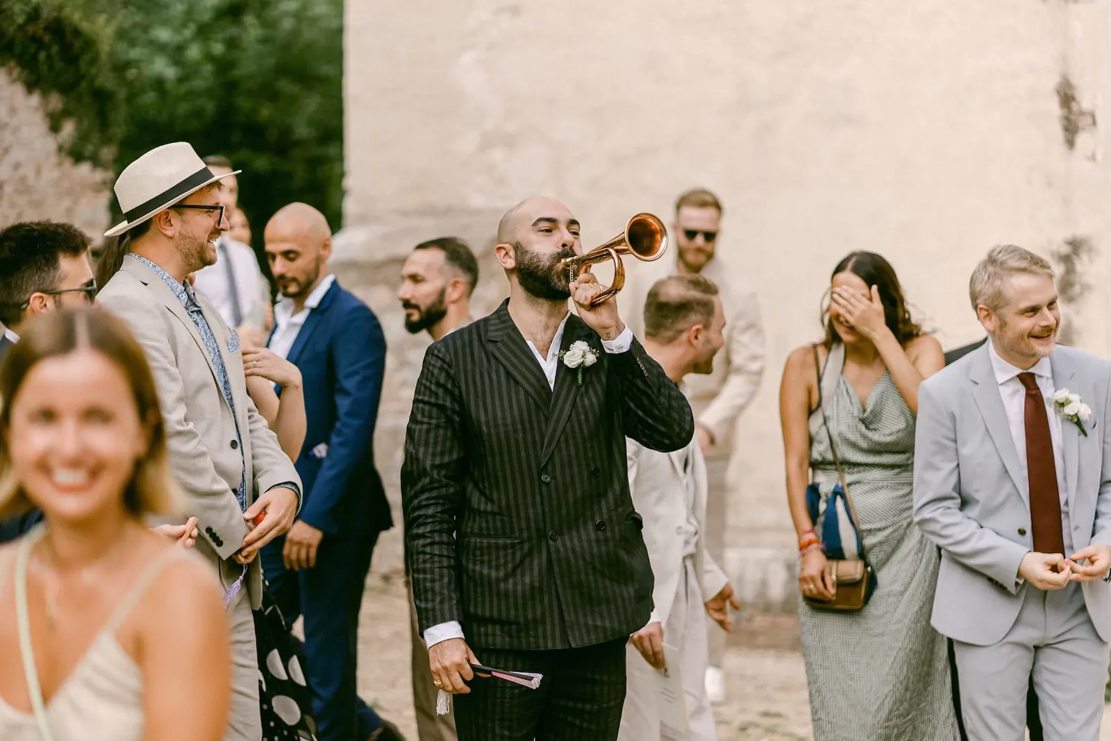 Un invitato suona la tromba tra gli amici mentre Thomas ride
