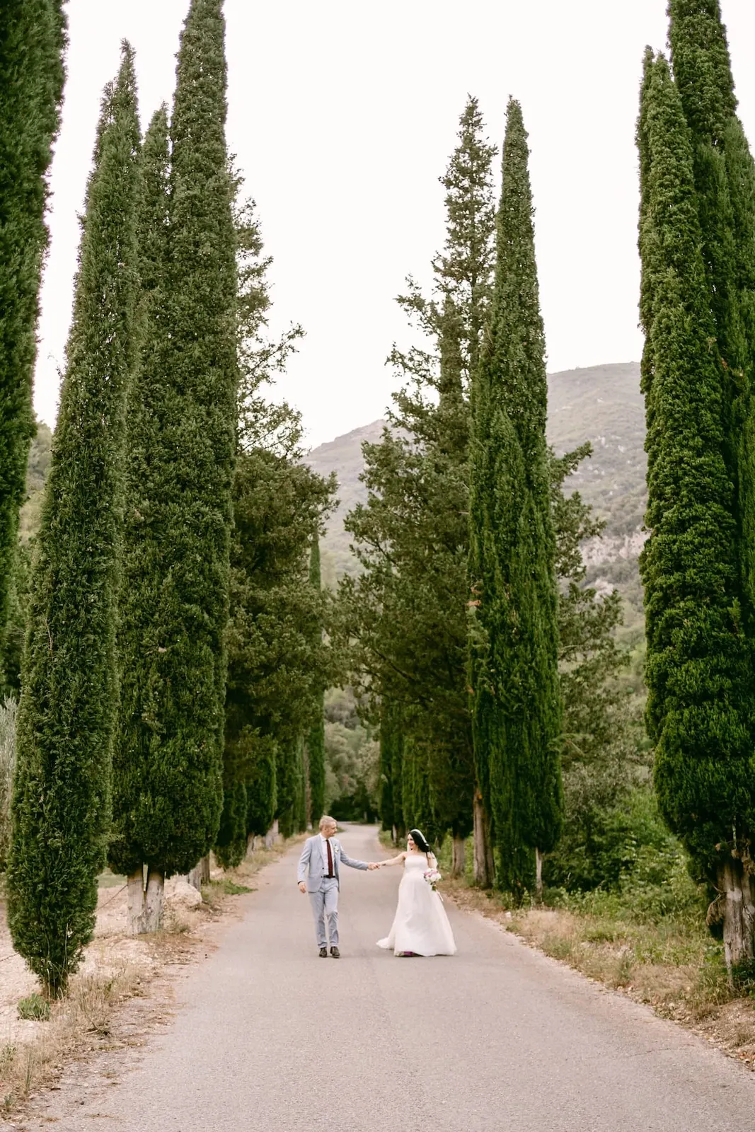 Gli sposi in lontananza nel viale dei cipressi