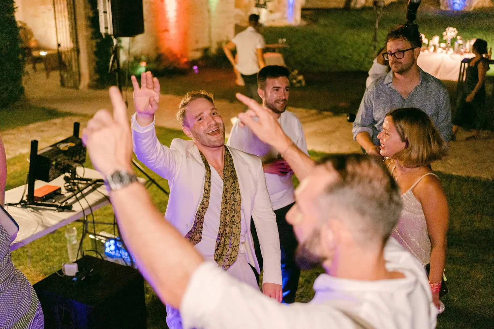 Gli invitati ballano a braccia alzate durante la festa