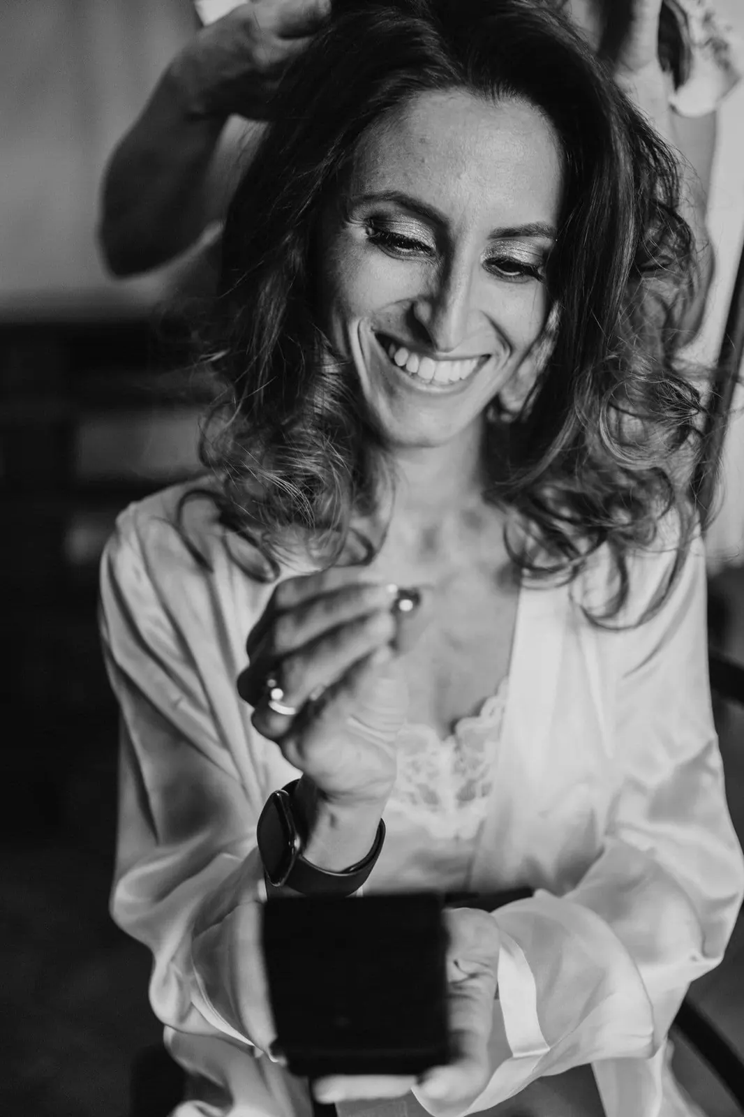 Giulia smiling as she opens a gift, in black and white
