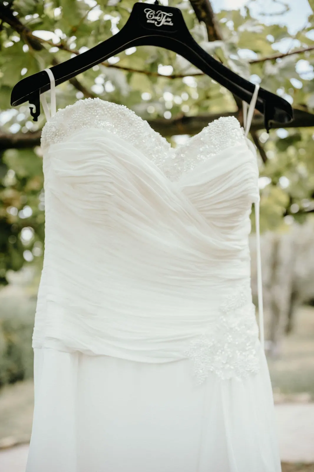 Detail of the wedding dress hanging among the trees